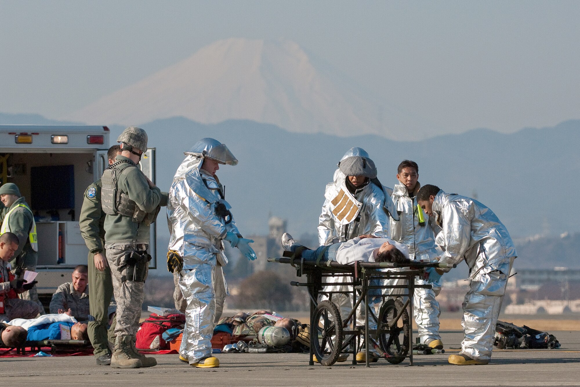Firefighters from the 374th Civil Engineer Squadron transport a patient to a casualty collection point following a simulated aircraft crash during an emergency management exercise Feb. 4, 2011, at Yokota Air Base, Japan. (U.S. Air Force photo/Osakabe Yasuo)