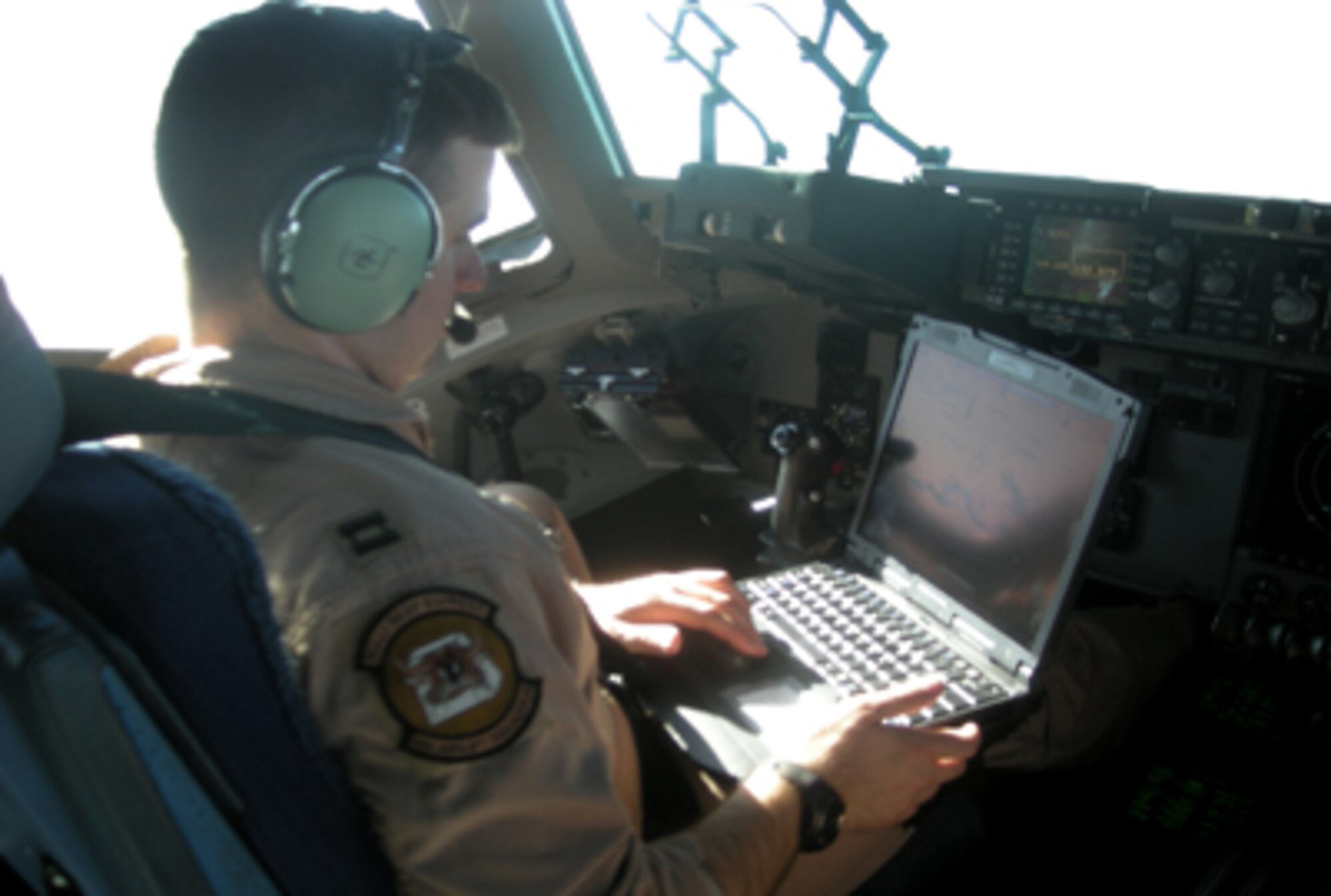 Capt. James Sprys operates Mission Index Flying software on an Air Mobility Command mission laptop computer. MIF uses airborne solution software in the cockpit, allowing aircrews to fly at optimal altitudes and airspeeds for their current flight conditions, thereby minimizing flight time and fuel burn and reducing operating costs. Captain Sprys is a 6th Airlift Squadron C-17 Globemaster III aircraft commander. (Courtesy photo)