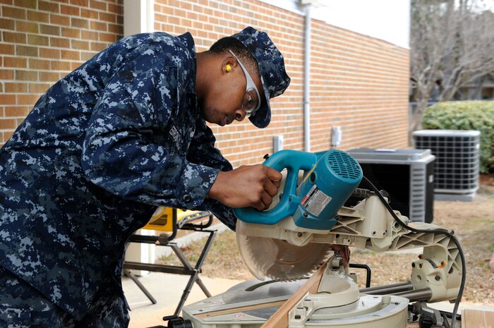 Ship’s Serviceman 2nd Class James Ebron, attached to the Naval Support Activity on Joint Base Charleston - Weapons Station, lines up a chop saw to cut a piece of molding trim that will be used during a refurbishment project of the Unaccompanied Personal Housing offices on JB CHS - WS,  Feb. 16. (U.S. Navy photo/Machinist’s Mate 3rd Class Brannon Deugan)