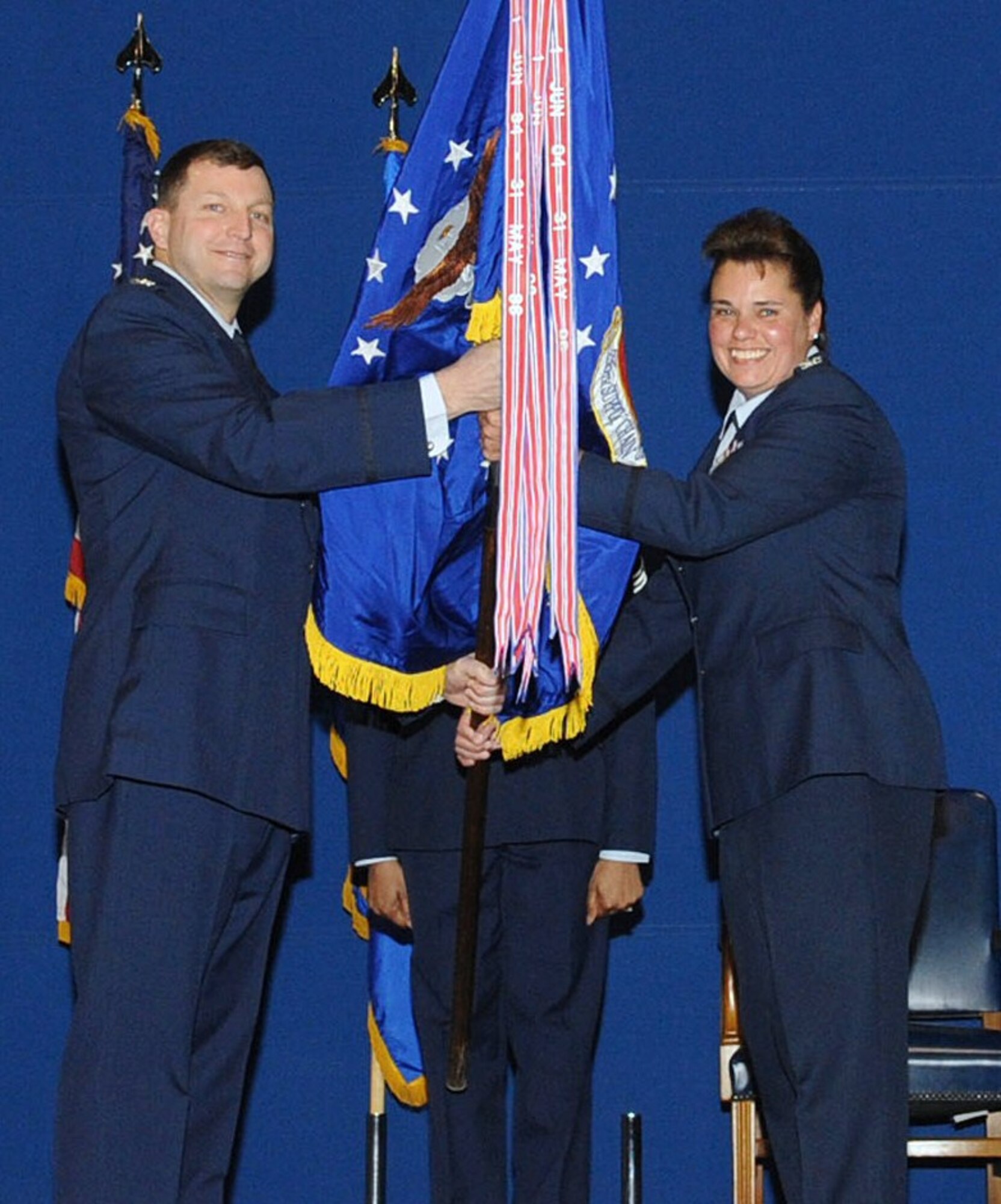 LANGLEY AIR FORCE BASE, Va. -- Col. Mark Johnson, 635th Supply Chain Operations Wing commander, passes the 735th Supply Chain Operations Group guidon to Col. Linda Hurry, the new 735 SCOG commander, during an assumption of command ceremony at the static display hangar Feb. 14. Colonel Hurry succeeded Col. Rick Bennett in command of the group. (U.S. Air Force photo/Staff Sgt. Ashley Hawkins) (RELEASED)