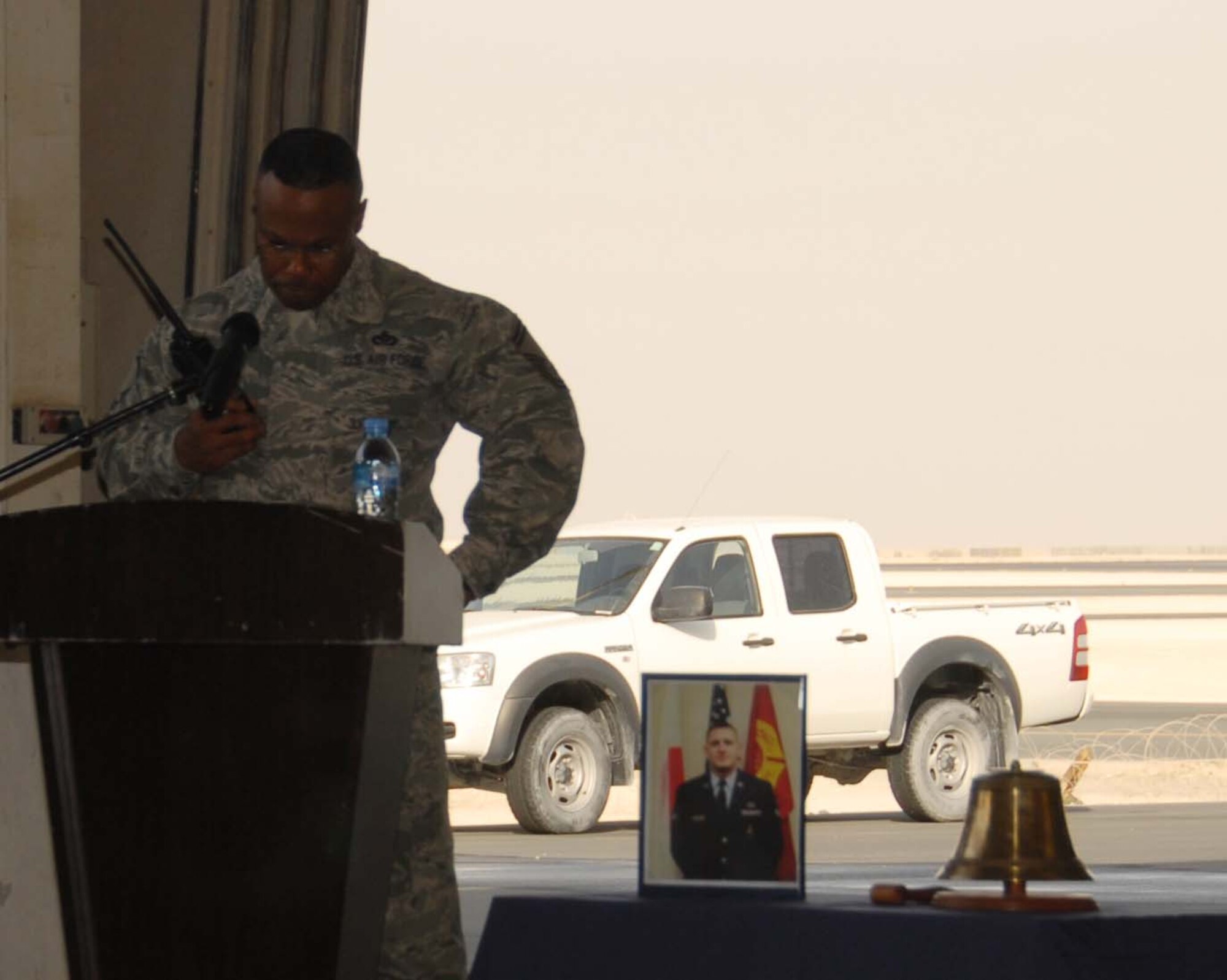 Senior Master Sgt. Elliott Smith, fire chief for the 379th Expeditionary Civil Engineer Squadron fire protection flight, radios dispatch for Senior Airman Derek Kozorosky as part of the Final Alarm/Last Call during a memorial service Feb. 16 in Southwest Asia. Airman Kozorosky died Feb. 11 after a vehicle incident at Kadena Air Base, Japan. Seven deployed co-workers attended his memorial service here. (U.S. Air Force photo/Staff Sgt. Anthony Graham)
