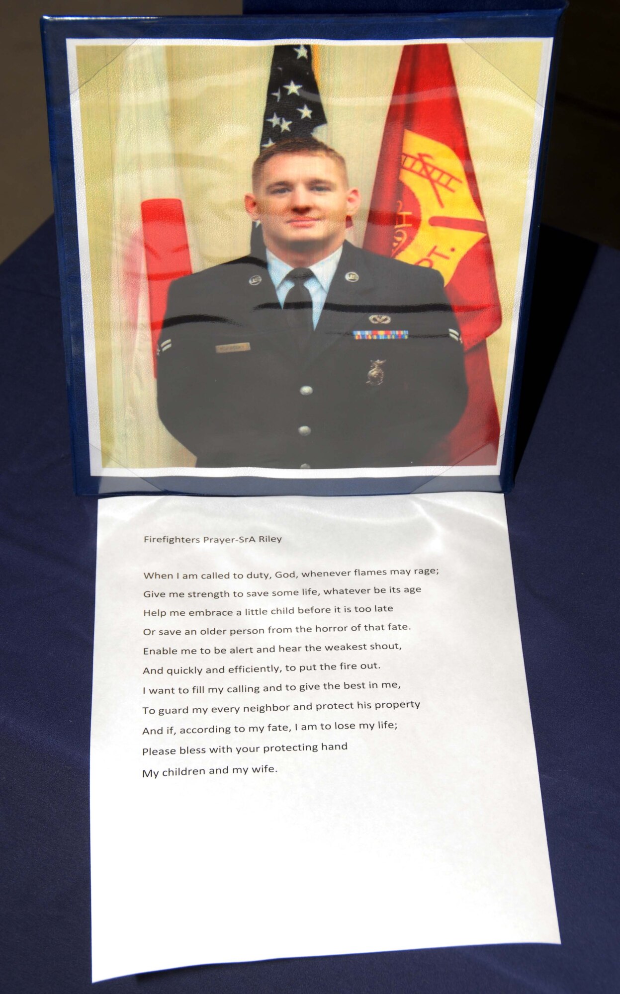 The Firefighter’s Prayer is displayed by a photo of Senior Airman Derek Kozorosky (then-Airman 1st Class), during Airman Kozorosky’s memorial service at a desert air base in Southwest Asia, Feb. 16. Airman Kozorosky died Feb. 11 after a vehicle incident at Kadena Air Base, Japan. Seven deployed co-workers attended his memorial service here. (U.S. Air Force photo/Staff Sgt. Anthony Graham)