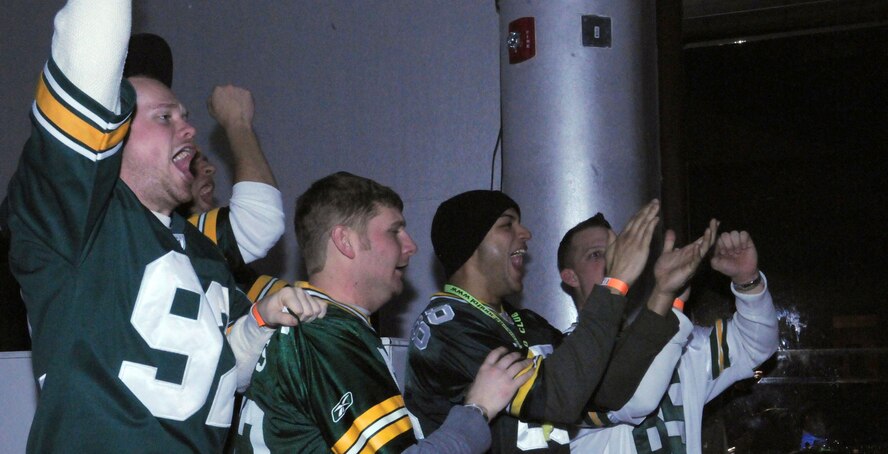 A group of Airmen cheers for their team at the Super Bowl XLV screening event at the consolidated club, Feb. 6-7, 2011, at Incirlik Air Base, Turkey. The event allowed Airmen to see the live broadcast of the game and get a taste of home, said 39th Force Support Squadron officials. The event was also the finale of the Incirlik Super Bowl commercial contest. Attendees had the opportunity to view and vote for their favorite locally-produced commercial. The first place winner received $10,000 in quality-of-life funds for the unit. (U.S. Air Force photo by 1st Lt. Gina McKeen/Released)