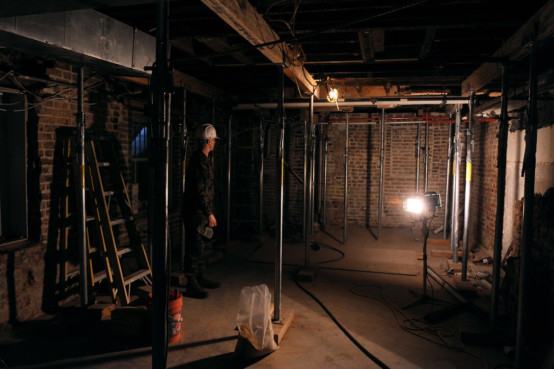 Maj. Pete Dahl, construction project manager, inspects the basement of the Home of the Commandants, which is undergoing repairs, Feb. 16. More than 20 supports in the basement prevent the building from collapsing. (Photo by Cpl. Austin Hazard)