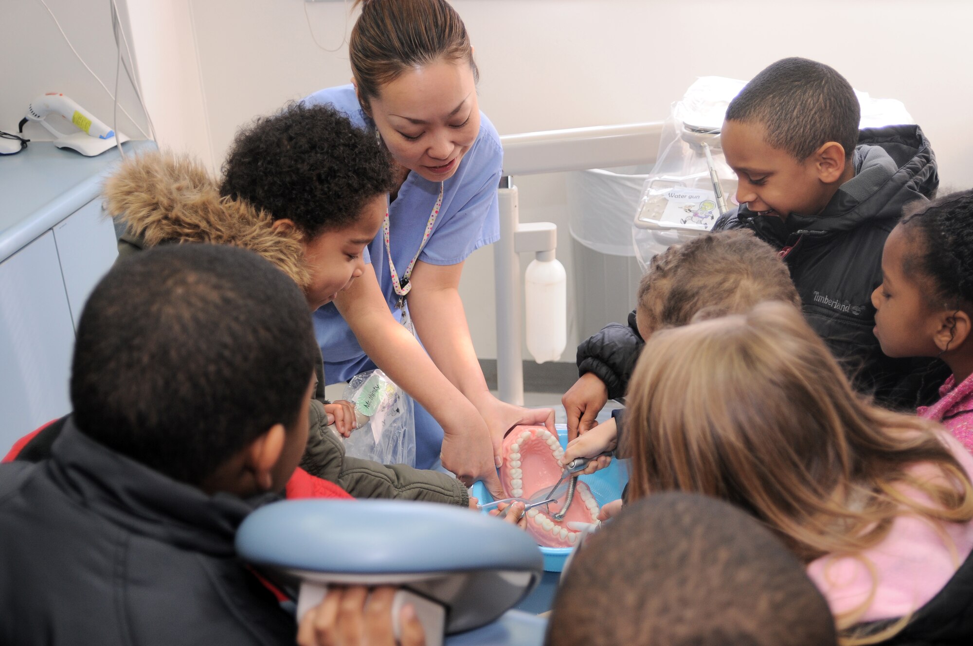 YOKOTA AIR BASE, Japan -- Matsumura Hozue, 374th Dental Squadron dental assistant, familiarizes kindergarten students from Joan K. Mendel Elementary School with tools used by dentists here Feb. 16.  Kindergarten students visited the dental clinic as part of National Children's Dental Health Month. (U.S. Air Force Photo/Airman John Partlow)