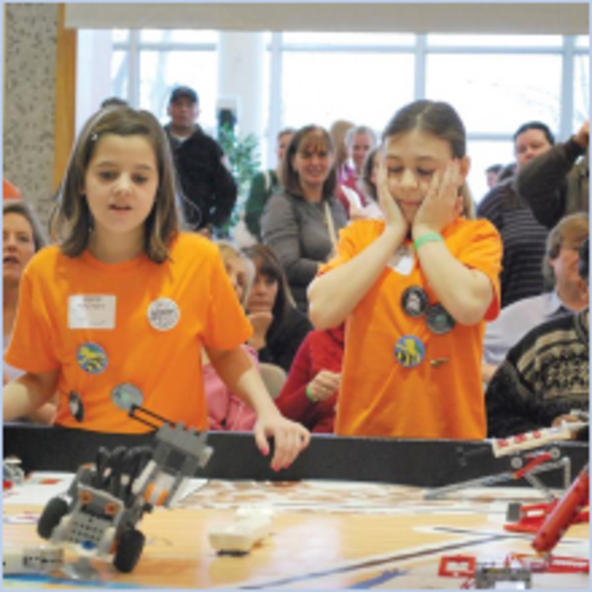 Taylor Monroe (left) and Gabby Collins, members of the Flying Tigers Team, react to action on the Robot Missions Table on Jan. 29 at the state competition of First Lego League. The competition held in the University of Utah Student Union Building drew 56 teams to the competition. (Courtesy of First Lego League)