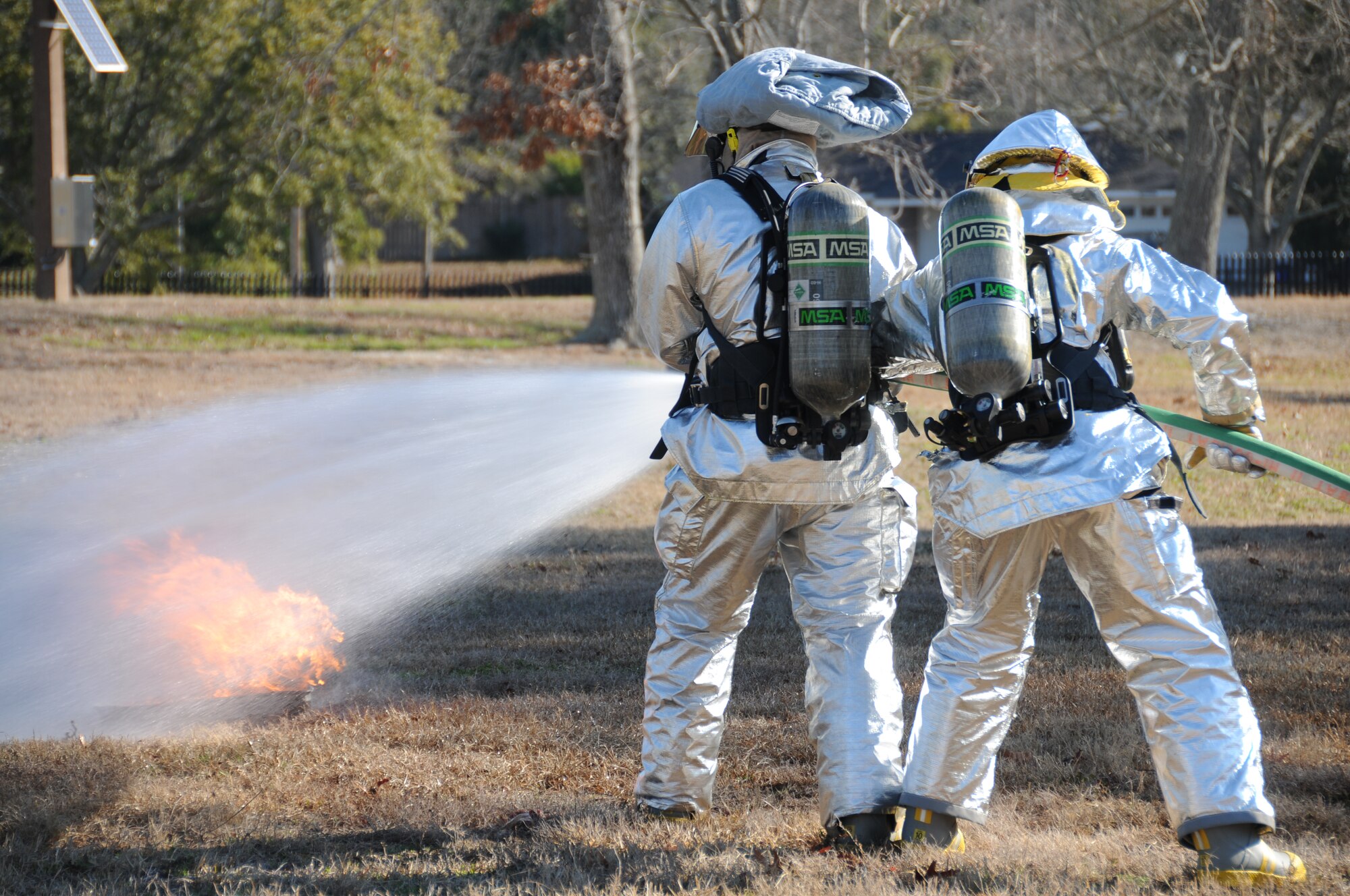 Keesler firemen put out a small fire as they arrive on scene.  The fire simulated the landing of an aircraft during today’s exercise in which Keesler responded to a mid-air collision of two Blue Angel’s F-18’s.   (U.S. Air Force photo by Kemberly Groue)
