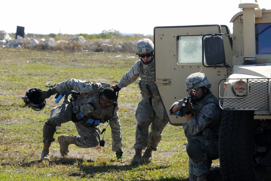 AVON PARK, Fla.-- Senior Airman Steven Smith is dragged into a waiting Humvee by fellow 823rd Base Defense Squadron fire team member Senior Airman Andrew Crist, as Senior Airman Camille Espinoza-Rojas, 823rd BDS fire team leader, provides cover fire during joint exercise ATLANTIC STRIKE 11-01 Feb. 16.  This joint exercise brought together all the necessary components used to provide realistic training before deployment. (U.S. Air Force photo/Airman 1st Class Benjamin Wiseman)(RELEASED)