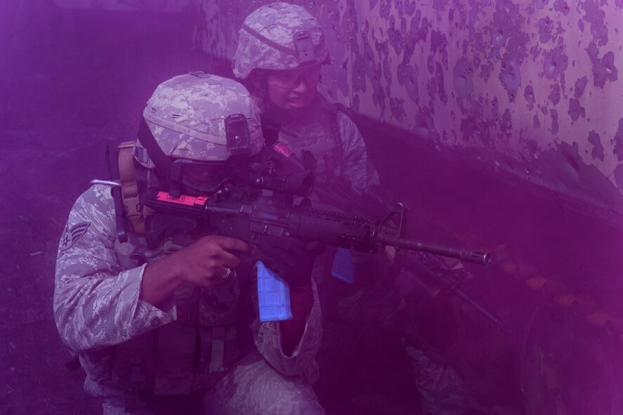 AVON PARK, Fla.-- Senior Airmen Bryan Davis and Camille Espinoza-Rojas, 823rd Base Defense Squadron, attack the opposing forces unit inside the mock village behind a cloud of purple smoke during joint exercise ATLANTIC STRIKE 11-01 Feb. 16. The 823rd BDS used smoke screens to conceal their movements through the city during the joint exercise. (U.S. Air Force photo/Airman 1st Class Benjamin Wiseman)(RELEASED)