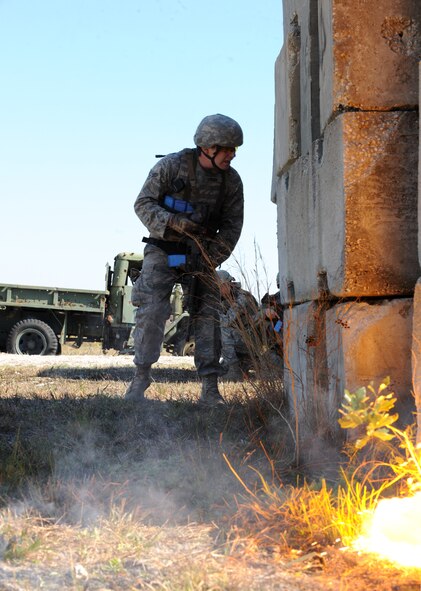AVON PARK, Fla.-- Airman 1st Class Chris Labuda, 823rd Base Defense Squadron fire team member, checks inside a building as a simulated improvised explosive device burns out during joint exercise ATLANTIC STRIKE 11-01 Feb. 15. The opposing forces team set up simulated IEDs, trip wires and fired small arms simulated rounds to slow the 823rd BDS down during their sweep of the mock village. (U.S. Air Force photo/Airman 1st Class Benjamin Wiseman)(RELEASED)