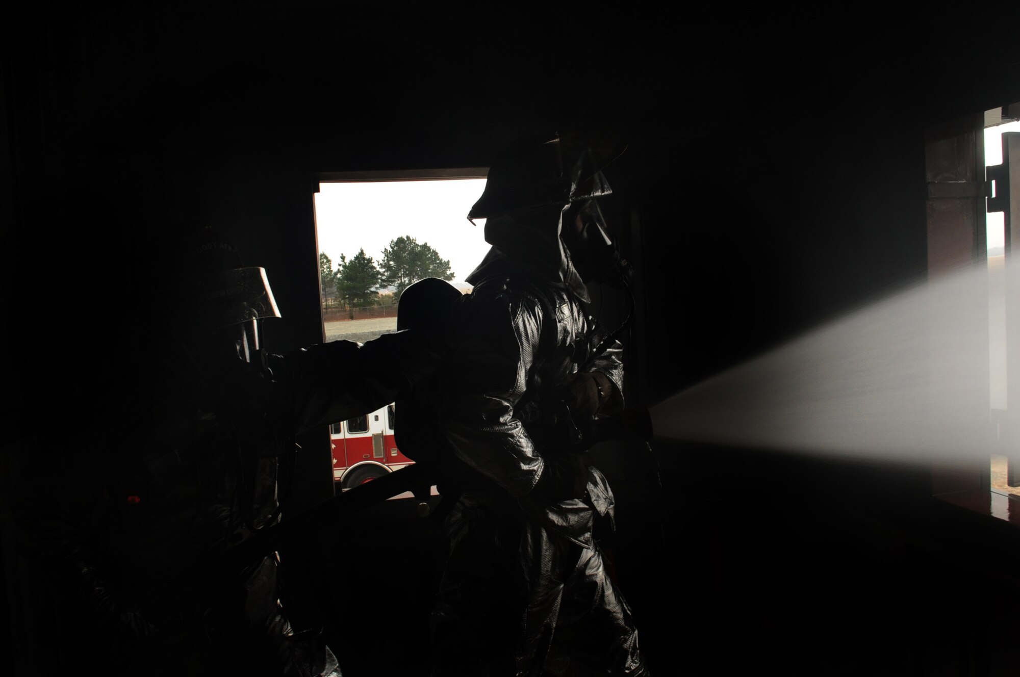 MOODY AIR FORCE BASE, Ga. -- Staff Sgt. Dwayne Peeples and Senior Airman Brian Bonner, 23rd Civil Engineer Squadron firefighters, spray water from a fire hose during a structural exercise Feb. 17. Each month, Moody’s fire department completes training on many topics, including infectious diseases and combat wildland firefighting.  (U.S. Air Force photo/Airman 1st Class Douglas Ellis)(RELEASED)
