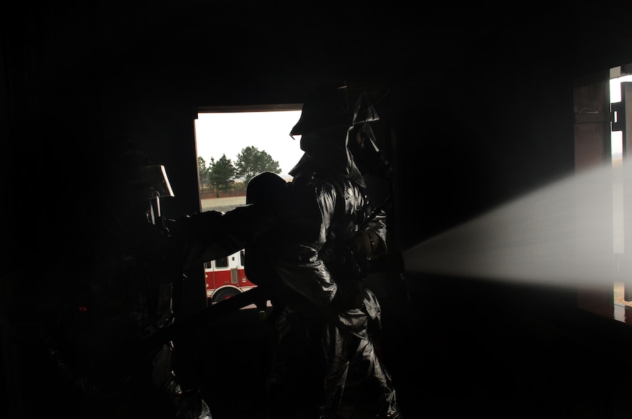 MOODY AIR FORCE BASE, Ga. -- Staff Sgt. Dwayne Peeples and Senior Airman Brian Bonner, 23rd Civil Engineer Squadron firefighters, spray water from a fire hose during a structural exercise Feb. 17. Each month, Moody’s fire department completes training on many topics, including infectious diseases and combat wildland firefighting.  (U.S. Air Force photo/Airman 1st Class Douglas Ellis)(RELEASED)
