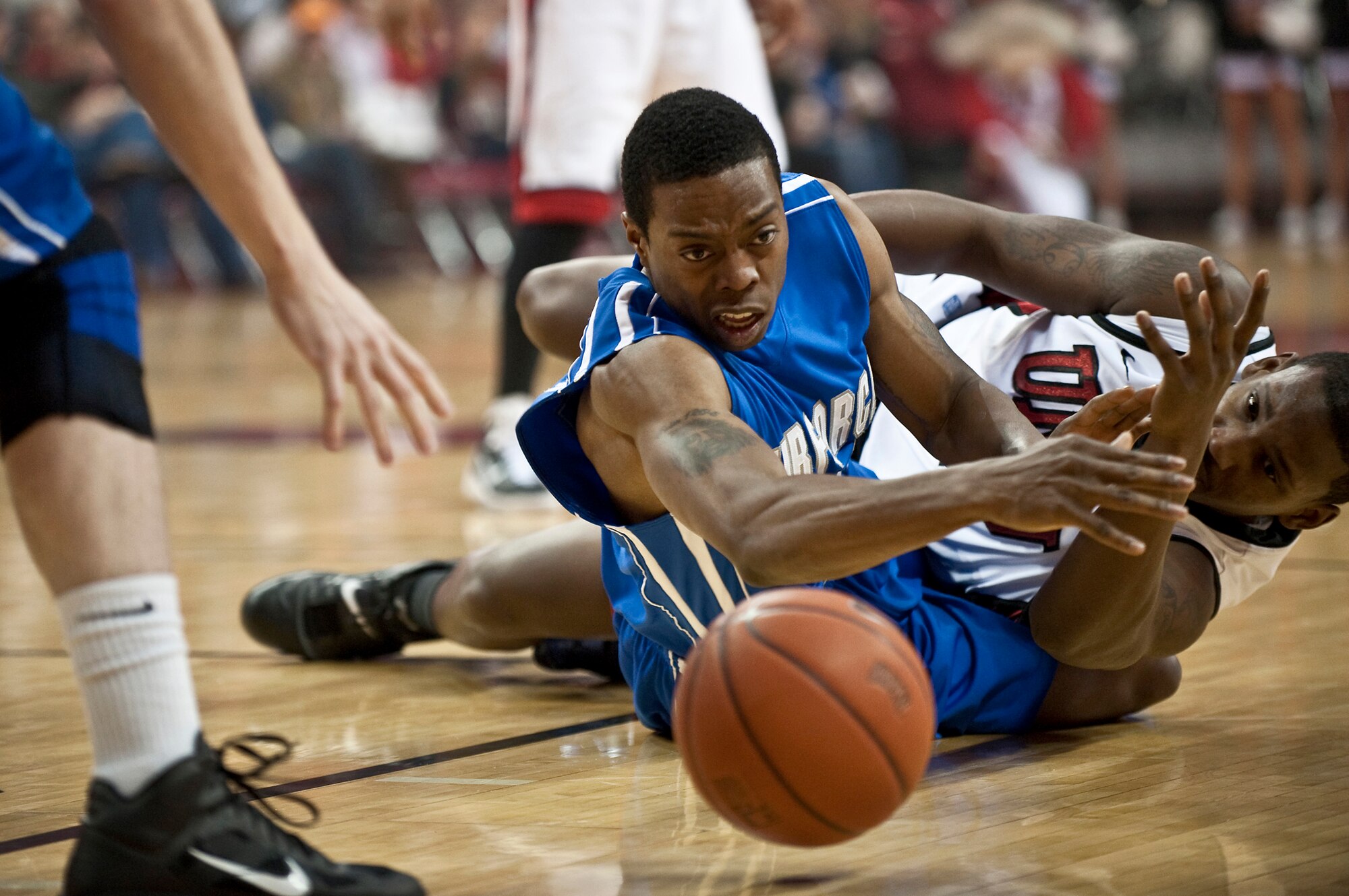 Falcons senior guard Evan Washington dives for a loose ball early in the first half of a mountain west conference basketball game against the University of Nevada, Las Vegas Runnin' Rebels Feb. 15, 2011, at the Thomas and Mac Center in Las Vegas, Nev. The Air Force Falcons came up short against UNLV 49-42, making their record 13-11 overall and 4-7 in the Mountain West Conference. (U.S. Air Force photo/Tech Sgt. Michael R. Holzworth)