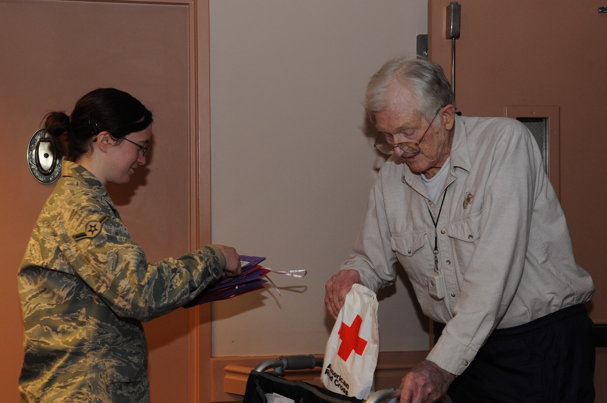 SEYMOUR JOHNSON AIR FORCE BASE, N.C. - Airman Heather Fogle gives a card to Winston Payne, a World War II veteran, during a Valentines for Veterans visit to The Pines Assisted Living Facility in Goldsboro, Feb. 10, 2011. Airmen from Seymour Johnson participated in a visit to the Pines to distribute cards made by local elementary school students and care packages donated by the American Red Cross. Airman Fogle is an aerospace ground equipment technician with the 4th Equipment Maintenance Squadron. (U.S. Air Force Photo Senior Airman Marissa Tucker) (RELEASED)