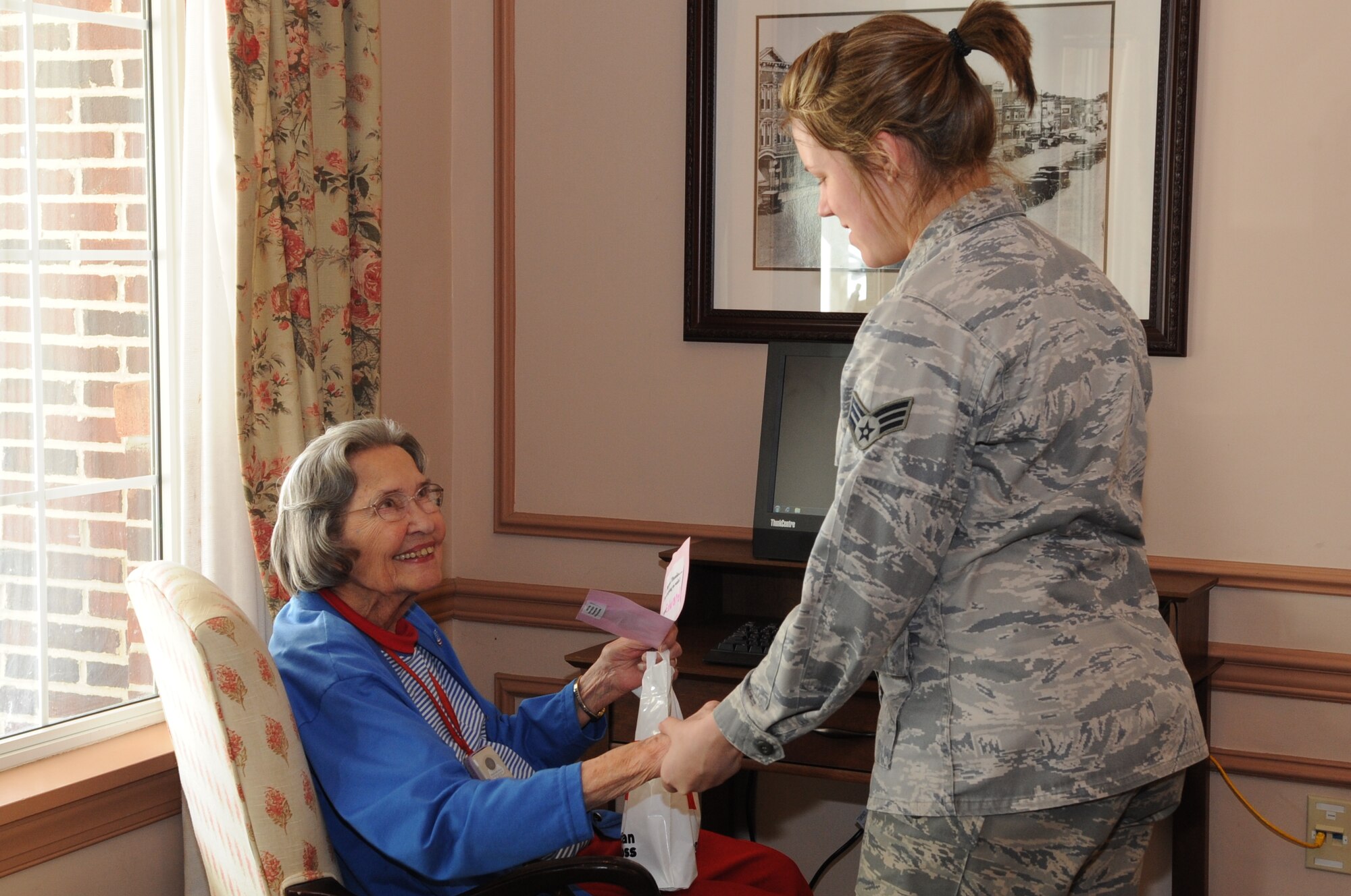 SEYMOUR JOHNSON AIR FORCE BASE, N.C. – Senior Airman Kenly Drescher gives a card and a care package to a resident of The Pines Assisted Living Facility during a visit Feb. 10, 2011. Airmen from Seymour Johnson make an annual trip to area assisted living facilities as part of the Valentines for Vets Program. While at The Pines, the Airmen gave cards and care packages to veterans and widows of veterans. Airman Drescher is a structural apprentice with the 4th Civil Engineer Squadron. (U.S. Air Force photo/Senior Airman Marissa Tucker) (RELEASED)