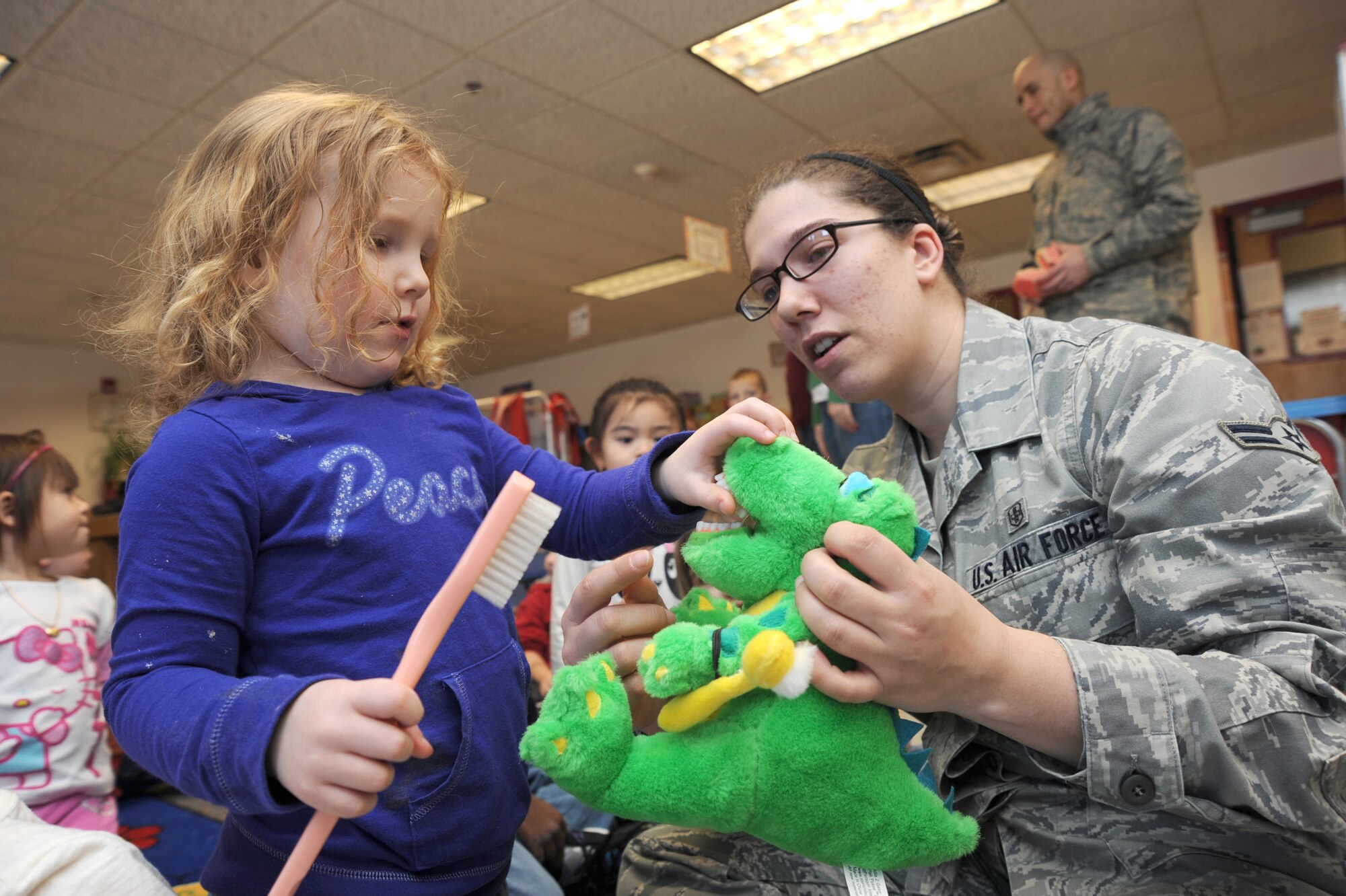 Isabel Gunter, 3 years old, learns how to brush her teeth from Airman 1st Class Stephanie Savaiano, 22nd Medical Group dental technician, at the Child Development Center, Feb. 11, 2011, McConnell Air Force Base, Kan. February is National Children’s Dental Health Month.  As a result, McConnell dental clinic visited the Child Development Center to discuss the importance of oral health to children.  (U.S. Air Force photo/Staff Sgt. Dallas Edwards)