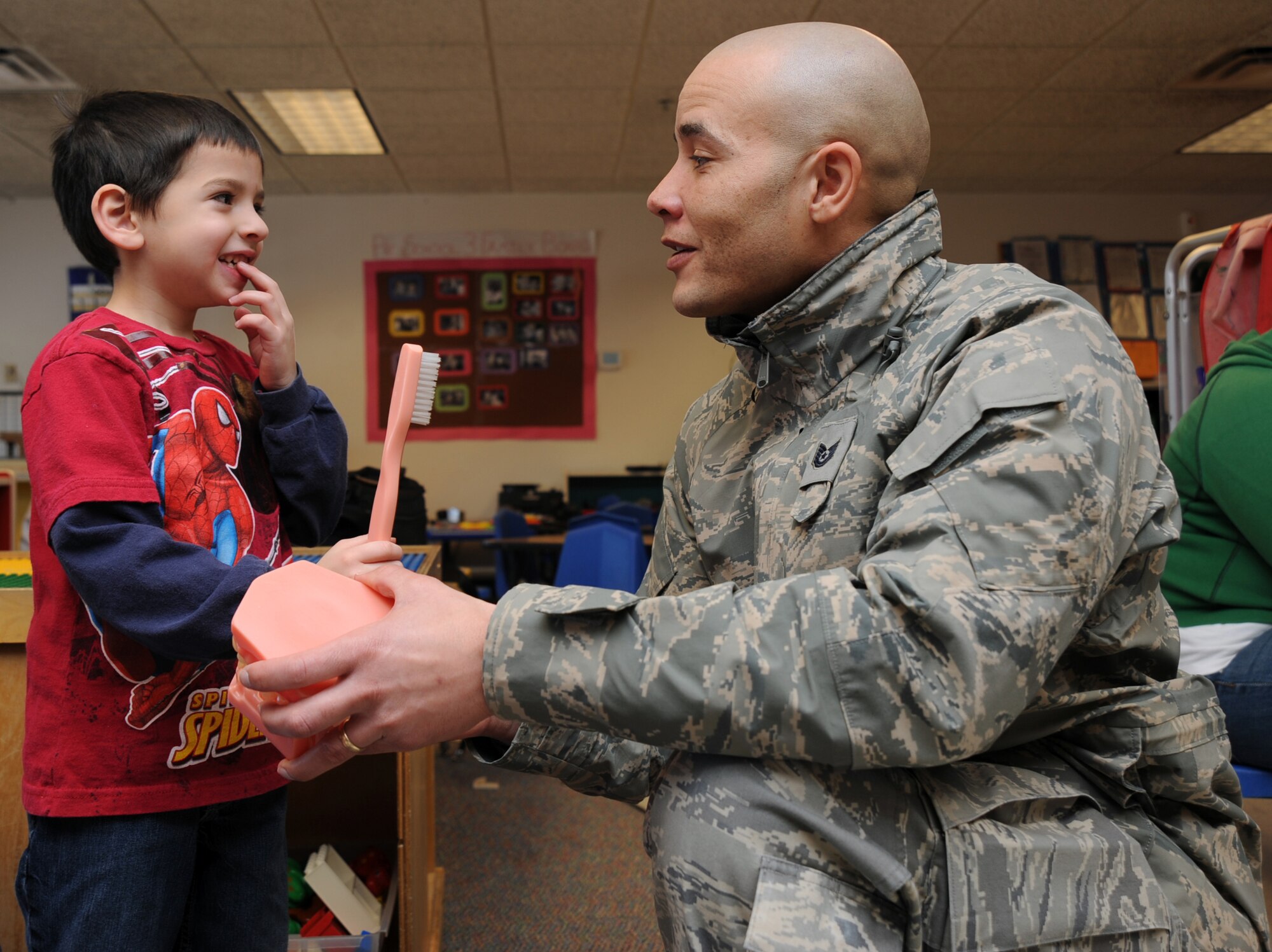 Tech. Sgt. Jason Staggers, 22nd Medical Group dental technician, talks to Kael Harrison, five years old, about brushing his teeth at the Child Development Center, Feb. 11, 2011, McConnell Air Force Base, Kan. February is National Children’s Dental Health Month.  As a result, the McConnell Dental Clinic visited the CDC to discuss the importance of oral health to children.  (U.S. Air Force photo/Staff Sgt. Dallas Edwards)