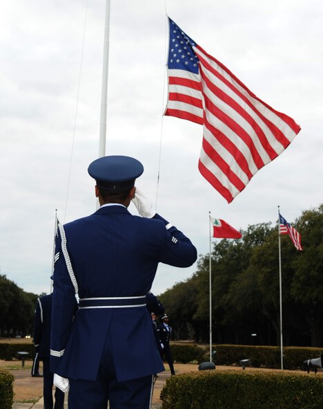 Senior Airman Devin Fields, Barksdale Honor Guard member, renders a salute as his team members lower the flag during retreat ceremony at the 2nd Bomb Wing Headquarters building at Barksdale Air Force Base, La., Feb. 16. (U.S. Air Force photo/Senior Airman Alexandra M. Boutte) (RELEASED)
