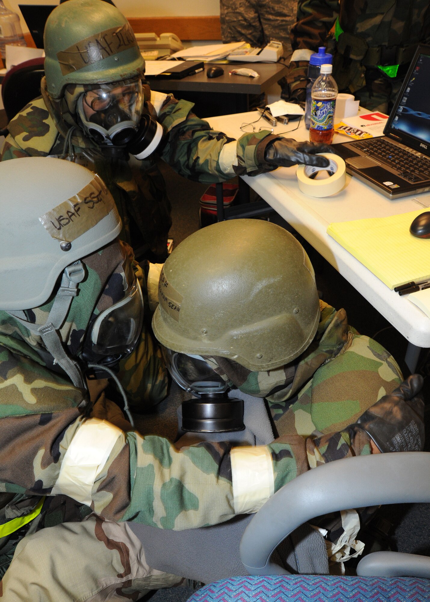 Second Lt. Jeff Choi and Staff Sgt. Quarteeya Garner, 22nd Contracting Squadron contract specialists, assist Airman 1st Class Sean Graham, 22nd Comptroller Squadron customer service technician, with a “wound” during an Operational Readiness Exercise Feb. 15, 2011, McConnell Air Force Base, Kan.  The ORE allows Airmen to practice their abilities in a simulated hostile environment, while executing their primary duties, applying self-aid buddy care and practicing different Mission Oriented Protective Posture conditions. (U.S. Air Force photo/Senior Airman Maria A. Ruiz) 