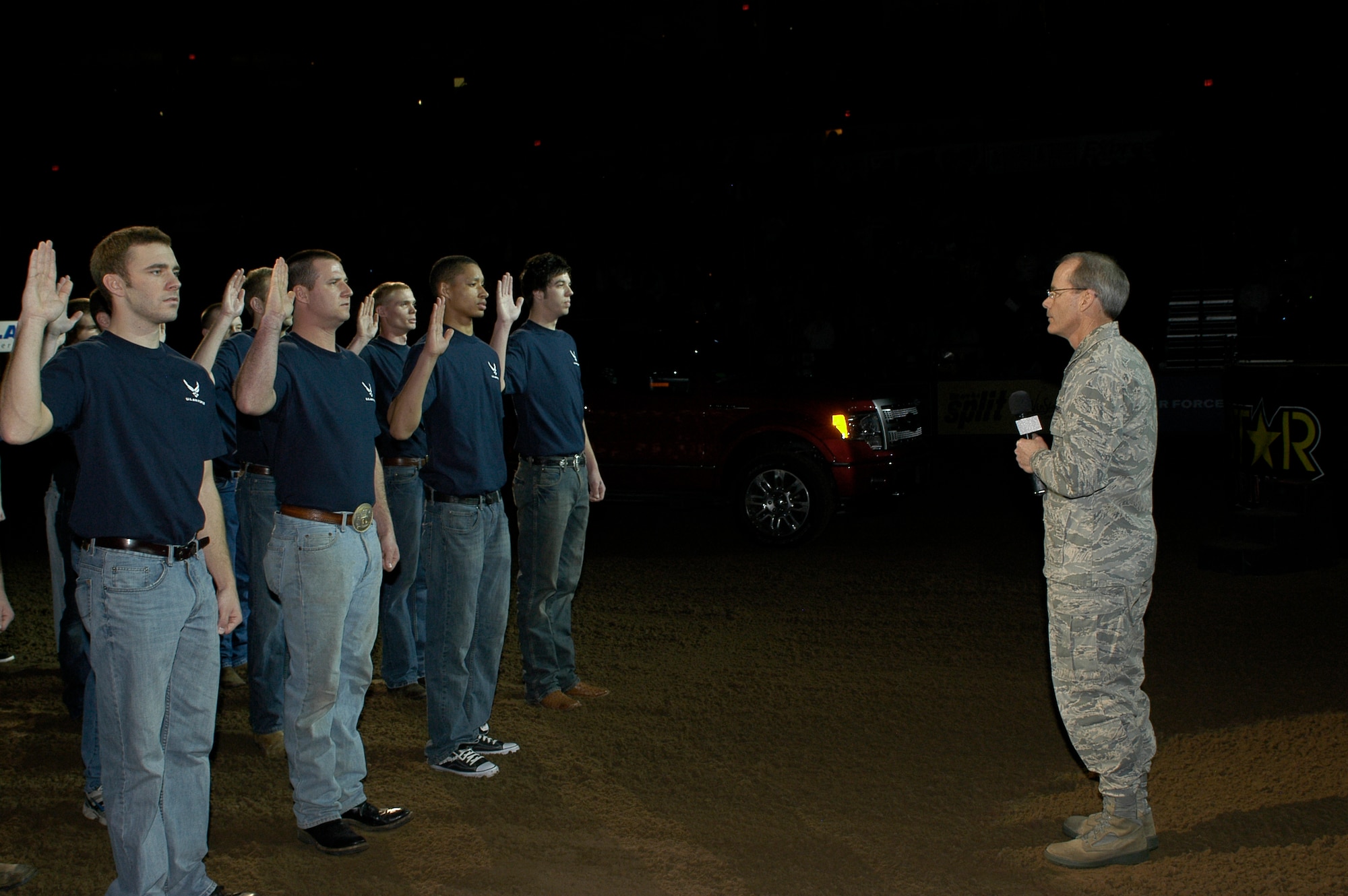 Col. Bob LaBrutta, 72nd Air Base Wing commander, right, performs the Oath of Enlistment to 56 Air Force recruits prior to the start of the PBR finals Feb. 13 at the Oklahoma City Arena in downtown Oklahoma City. The Air Force was one of the major sponsors for this year’s events. (Air Force photo by Darren D. Heusel)
