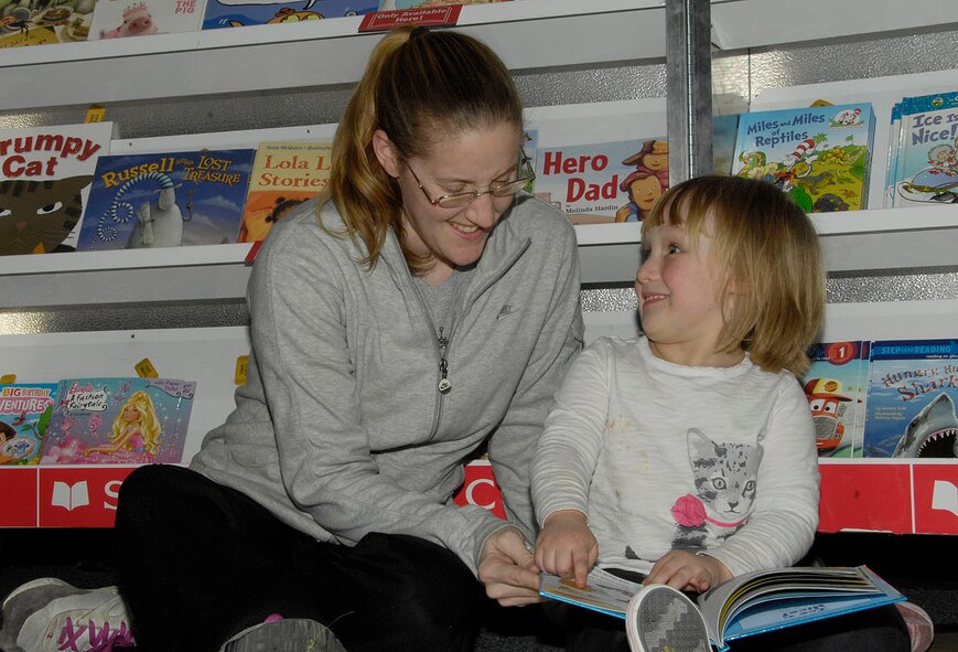 HANSCOM AIR FORCE BASE, Mass. - Laurene LaFluer (left) takes a minute to read a book to Abby Herlihy during the Scholastic Book Fair at the Child Development Center on Feb. 8. Grandparents, parents and special guests were invited to the CDC to read books to children during the fair. (U.S. Air Force photo by Linda LaBonte Britt)
