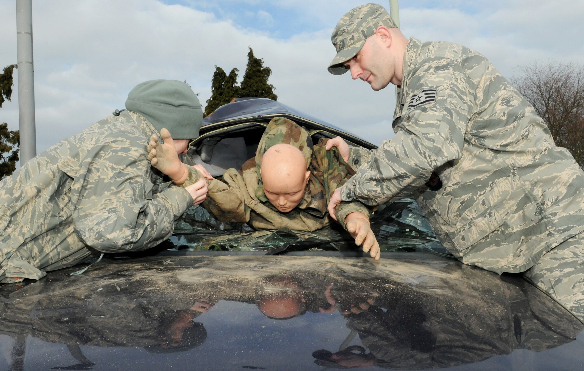 RAF MILDENHALL, England -- Staff Sgts. Natalie Turner, 100th Air Refueling Wing Safety Office NCO in charge of ground safety, and David Jones, 100th Civil Engineer Squadron firefighter, position a crash dummy in a wrecked car here Feb. 16, 2011. Wrecked cars were placed at two exit gates to keep Team Mildenhall aware of the hazards of reckless driving and the dangers of vehicle rollover accidents. (U.S. Air Force photo/Senior Airman Tabitha M. Lee)