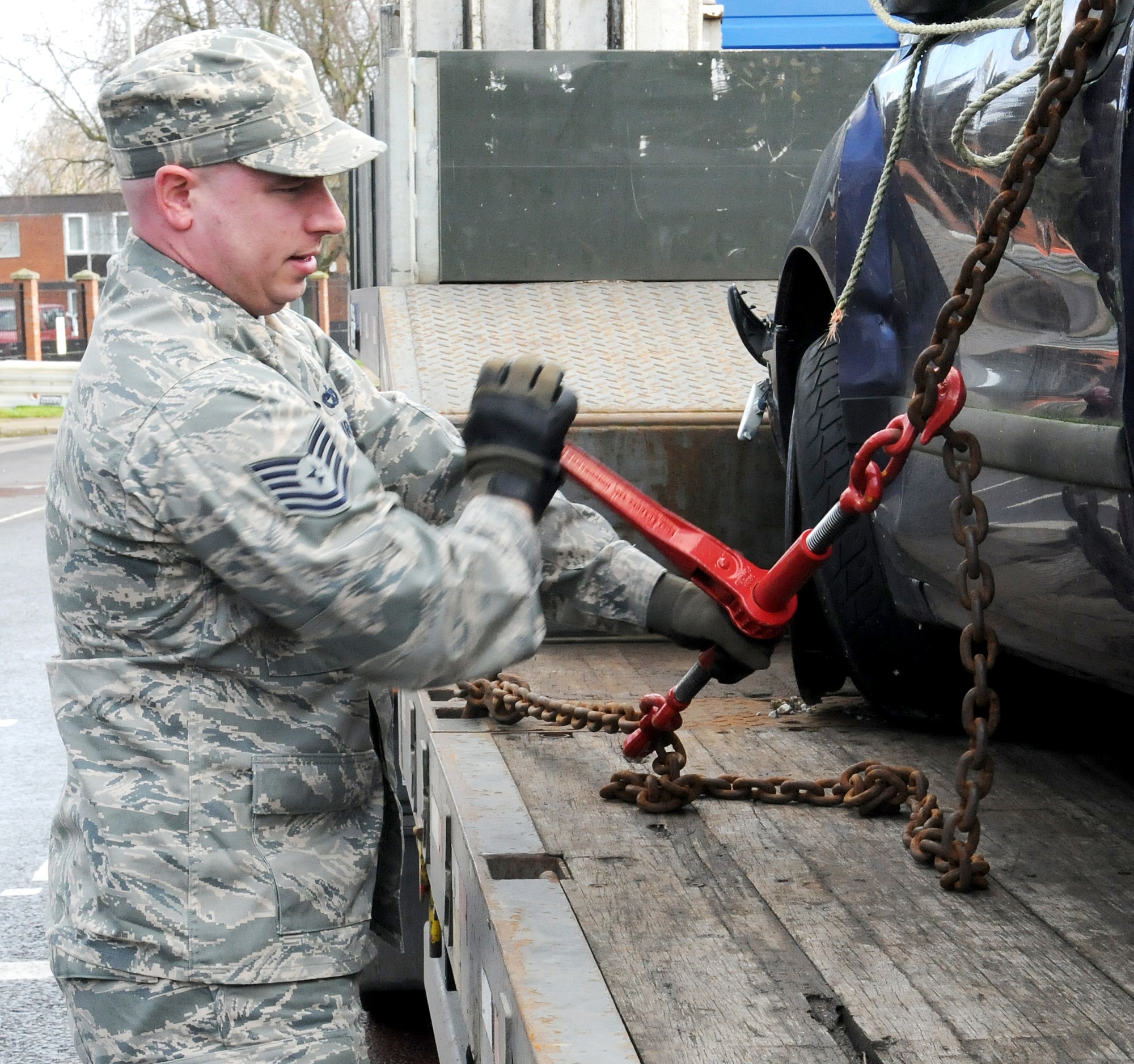 RAF MILDENHALL, England -- Tech. Sgt. Joshua Maul, 100th Logistics Readiness Squadron training and validations operations NCO in charge, removes a restraint chain from a vehicle here Feb. 16, 2011.  Wrecked cars were placed at the Bird in Hand and West Row gates to keep Team Mildenhall aware of the hazards of reckless driving and the dangers of vehicle rollover accidents. (U.S. Air Force photo/Senior Airman Tabitha M. Lee)  