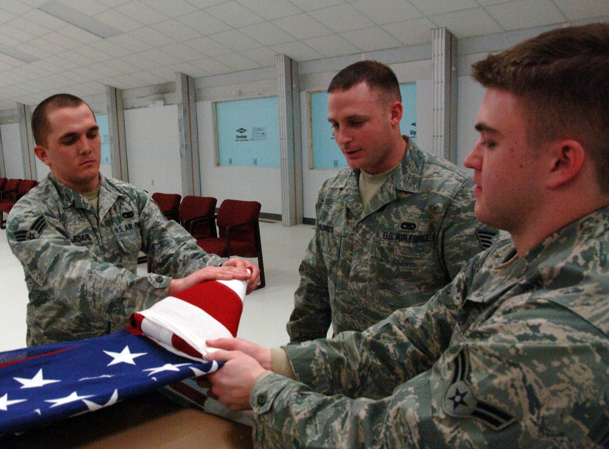 Staff Sgt. George Childres, 319th Force Support Squadron Honor Guard program manager, oversees the folding process of the American flag during a funeral ceremony practice Feb. 10 on Grand Forks Air Force base. Sergeant Childres is the warrior of the week for Feb. 17 through 24. Warrior of the Week recognizes everyday Airmen performing their every day jobs. (U.S. Air Force photo by Airman Derek VanHorn)