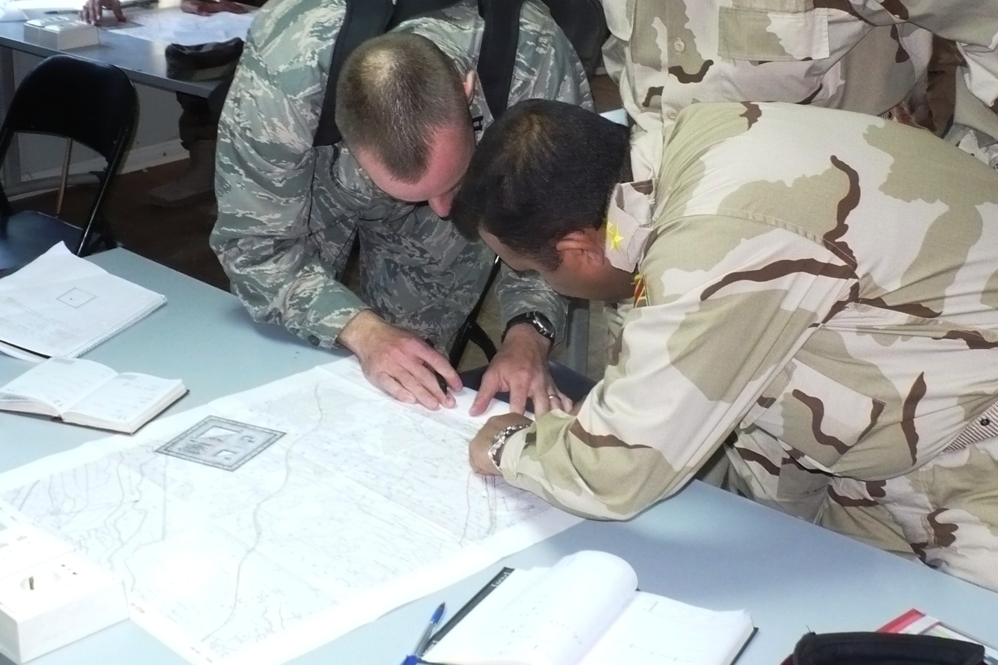 ALI AIR BASE, Iraq -- Capt. Kenneth Howell, a munitions maintenance officer from Sheppard Air Force Base, Texas, reviews map coordinates with an Iraqi airman during a class conducted by the Joint Air Operations Integration Team.  The JAOIT is an Iraq Training and Advisory Mission – Air team training different branches of the Iraqi military how to work together seamlessly. (Courtesy Photo)