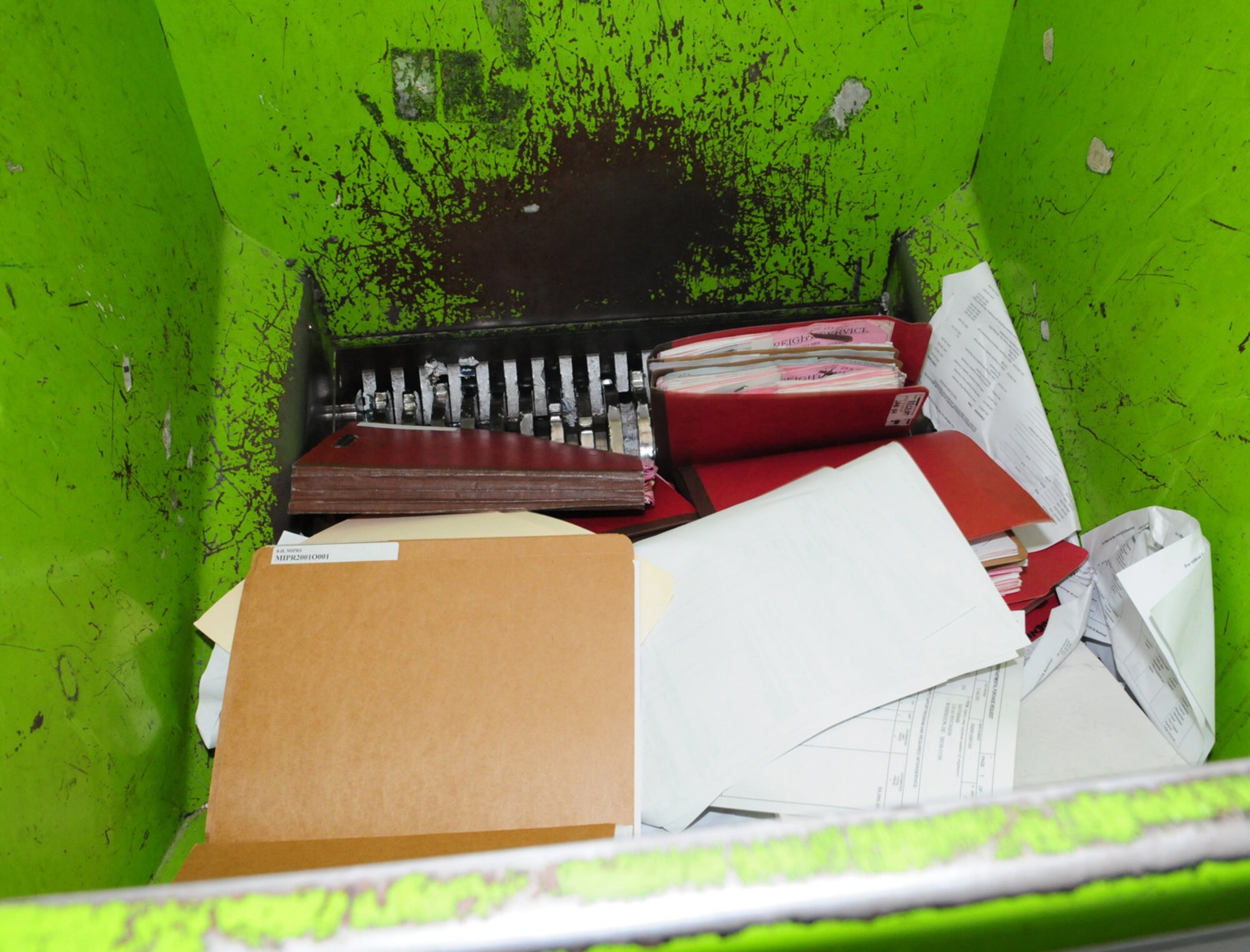 RAF MILDENHALL, England -- Old, outdated files and paper sink into a shredder Feb. 17, 2011. Employees from around the base brought over mass recycling to load into the industrial shredder temporarily parked in a base parking lot. The shredder can be loaded with items including paper, cardboard, computer hard drives, discs and videotapes. It can shred up to two tons of material per hour. (U.S. Air Force photo/Karen Abeyasekere)