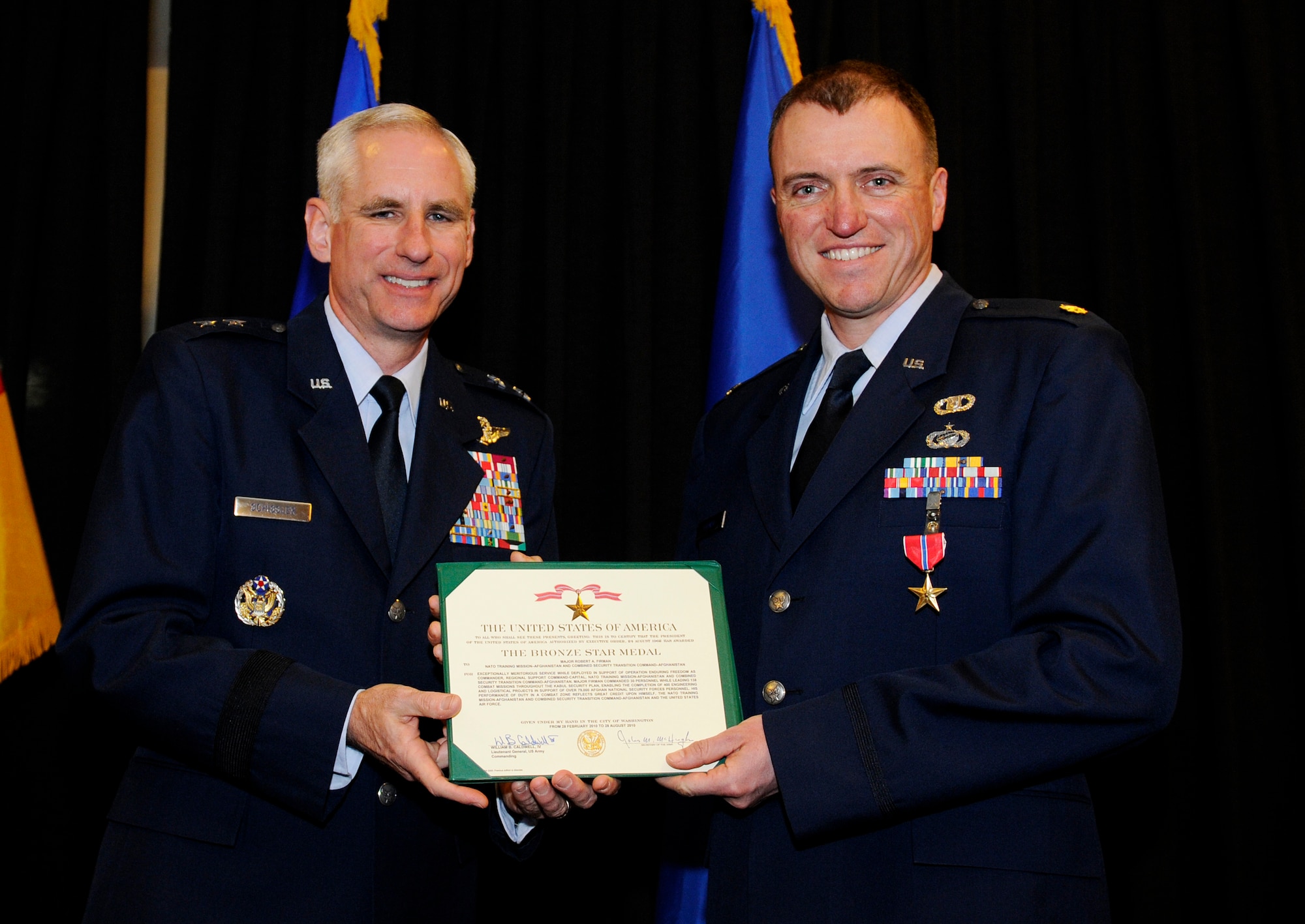 Maj. Gen. Mark Schissler, U.S. Air Forces in Europe director of the Plans, Programs and Analyses Directorate, presents the Bronze Star to Maj. Robert Firman, USAFE Directorate of Plans, Programs and Analyses executive officer, Feb. 14, 2011, at Ramstein Air Base, Germany. Major Firman was deployed as the Regional Support Command-Capital commander, NATO Training Mission - Afghanistan and Combined Security Transition Command ? Afghanistan, from Feb. 28 to Aug. 28, 2010. While filling a billet normally reserved for an Army Combat Arms colonel, Major Firman led 138 combat operations throughout Kabul Province. He developed and implemented the Kabul Security Plan, partnering with the Afghan Ministry of Defense and Ministry of Interior to plan and execute the fastest growth phase for the Afghan National Security Forces since its inception. The Bronze Star is awarded to a person in any branch of the military service who, while serving in any capacity with the U.S. Armed Forces on or after Dec. 7, 1941, shall have distinguished himself by heroic or meritorious achievement or service, not involving participation in aerial flight, in connection with military operations against an armed enemy. It can also be awarded for heroism while serving with friendly forces engaged in combat against an opposing military. (U.S. Air Force photo by Tech. Sgt. Sarayuth Pinthong)