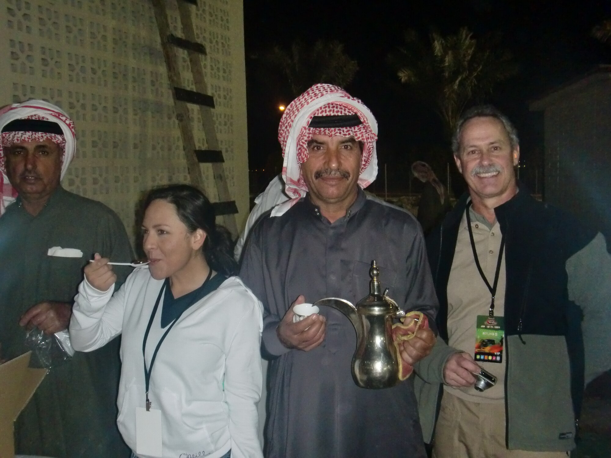 Staff Sgt. Sarai Akers, 379th Expeditionary Operations Support Squadron, and Steve Wisniewski, 379th Air Expeditionary Wing Inspector General, gather with host nation residents to partake in traditional tea and deserts at the Arabian drag races.  (U.S. Air Force photo/Senior Airman Veronica McMahon)

