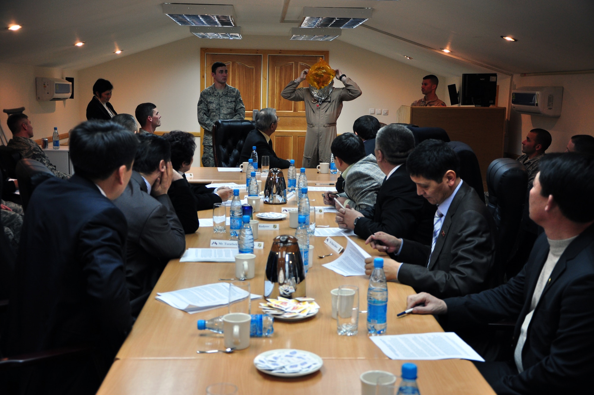 TRANSIT CENTER AT MANAS, Kyrgyzstan - Senior Master Sgt. Charles Jetton, 376th Expeditionary Operations Group, demonstrates the donning of the Emergency Portable Oxygen System in a safety briefing prior to a first-ever aerial refuel flight for members of the Kyrgyz Parliament 16 Feb.  Parliament members were taken on a KC-135 Stratotanker for a demonstration refueling mission with a C-17 Globemaster III over the skies of Kyrgyzstan. This demonstration of air power highlighted to the parliamentarians the role of the Aerial Refuel mission here, one of the Transit Center's four mission pillars. The other three pillars which were highlighted in the pre-flight briefing are Onward Movement, Airlift and Humanitarian Assistance. (U.S. Air Force photo/Master Sgt. Daniel Nathaniel) 