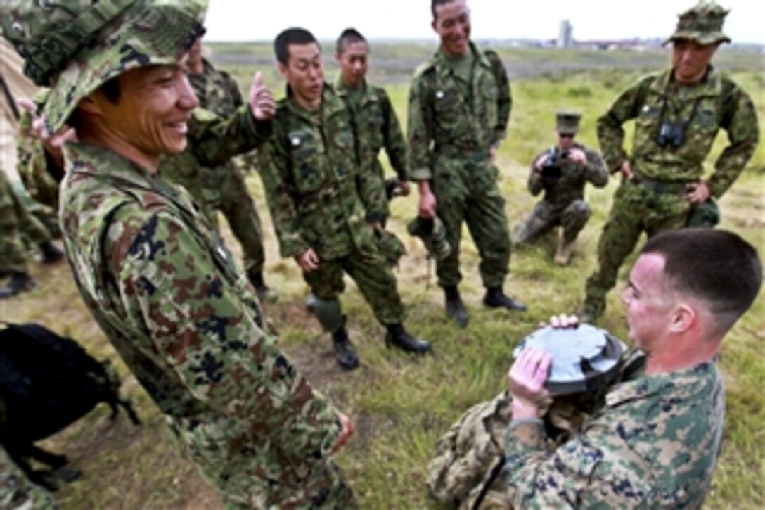 U.S. Marine Corps Sgt. Nicholas Parks shows Japanese soldiers the weights he had in his pack during their three-mile march during Iron Fist on Camp Pendleton, Calif., Feb. 15, 2011. Parks is assigned to Alpha Company, 1st Reconnaissance Battalion. Iron Fist is a training exercise between the U.S. and Japanese militaries to increase interoperability.