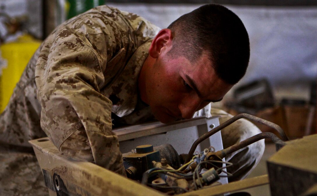 Sgt. John T. Flowers, refrigeration maintenance chief, Support Company, Combat Logistics Battalion 3, 1st Marine Logistics Group (Forward), repairs an air-conditioning unit aboard Camp Dwyer, Afghanistan, Feb. 17. Marines with CLB-3's Utilities Section have repaired nearly 300 generators and utility equipment for Marine units operating in Afghanistan's Helmand province.