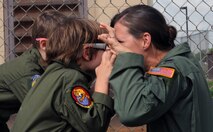 1st Lt. Audrey McCabe 535th Airlift Squadron C-17 Globemaster pilot and "Pilot for a Day" program "wingman," challenges Zachary Tyrell (front) and his sister Haley to make their best "tiger face" in honor of the 535th AS mascot before watching a military working dog demonstration Feb. 18 at the kennels during a "Pilot for a Day" tour on Joint Base Pearl Harbor Hickam, Hawaii. The goal of the program is to benefit children and their families in the local community who have catastrophic illnesses. Haley recently been declared cancer free after recovering from a cancerous brain tumor she was diagnosed with nearly two years ago. (U.S. Air Force photo/Staff Sgt. Nathan Allen)