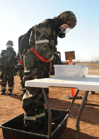 DYESS AIR FORCE BASE, Texas—Airman 1st Class Evan Mills, 7th Bomb Wing Public Affairs, simulates self-decontamination Feb. 17 during an ability to survive and operate training competition here. To help prepare for the upcoming Operational Readiness Exercise, Dyess held a competition between squadrons to test their ability to operate and survive during war time. The competition consisted of different obstacles such as self-aid and buddy care, vehicle decontamination, self-decontamination and answering a variety of questions. To succeed Airmen had to work together and finish each obstacle thoroughly and quickly. (U.S Air Force photo/ Airman 1st Class Shannon Hall)