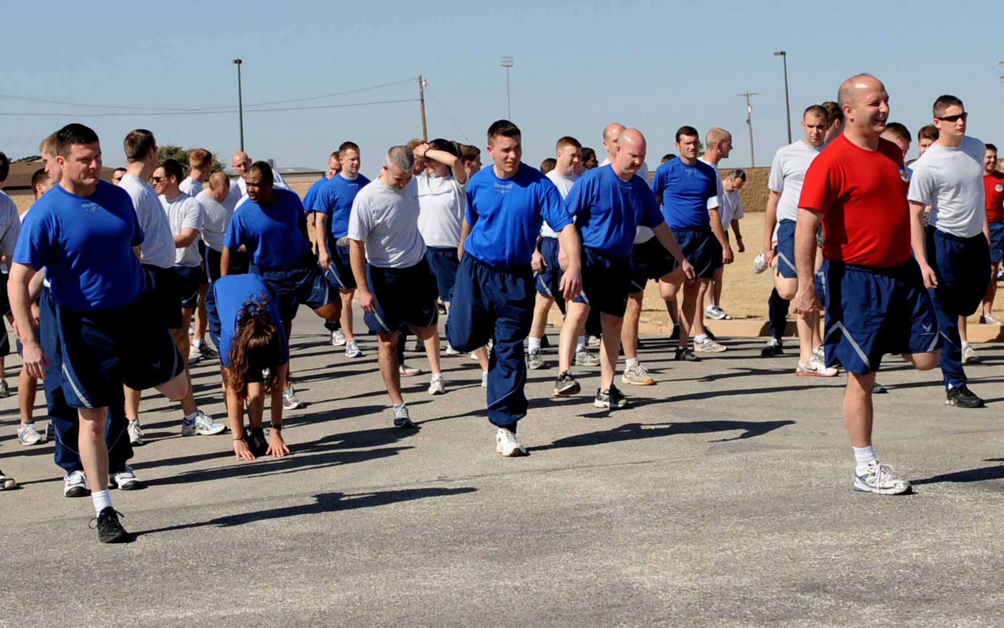 DYESS AIR FORCE BASE, Texas—Airmen from the 317th Airlift Group stretch together Feb. 18 before running a mile here as part of Wingman Day.  The squadron had a no fly day so they could concentrate more on people as opposed to the aircraft. Their main objective was to work on resiliency so Airmen could learn to bounce back quickly and efficiently after going through tough times. (U.S Air Force photo/ Airman 1st Class Shannon Hall) 