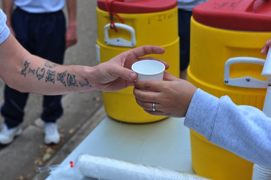 A runner reaches for water from a volunteer during the "Bring Your Valentine" 5k Run on Barksdale Air Force Base, La., Feb. 18. Three water stations were posted to keep the runners hydrated and Gatorade was also distributed at the finish line. (U.S. Air Force photo /Airman 1st Class Micaiah Anthony)(Released)