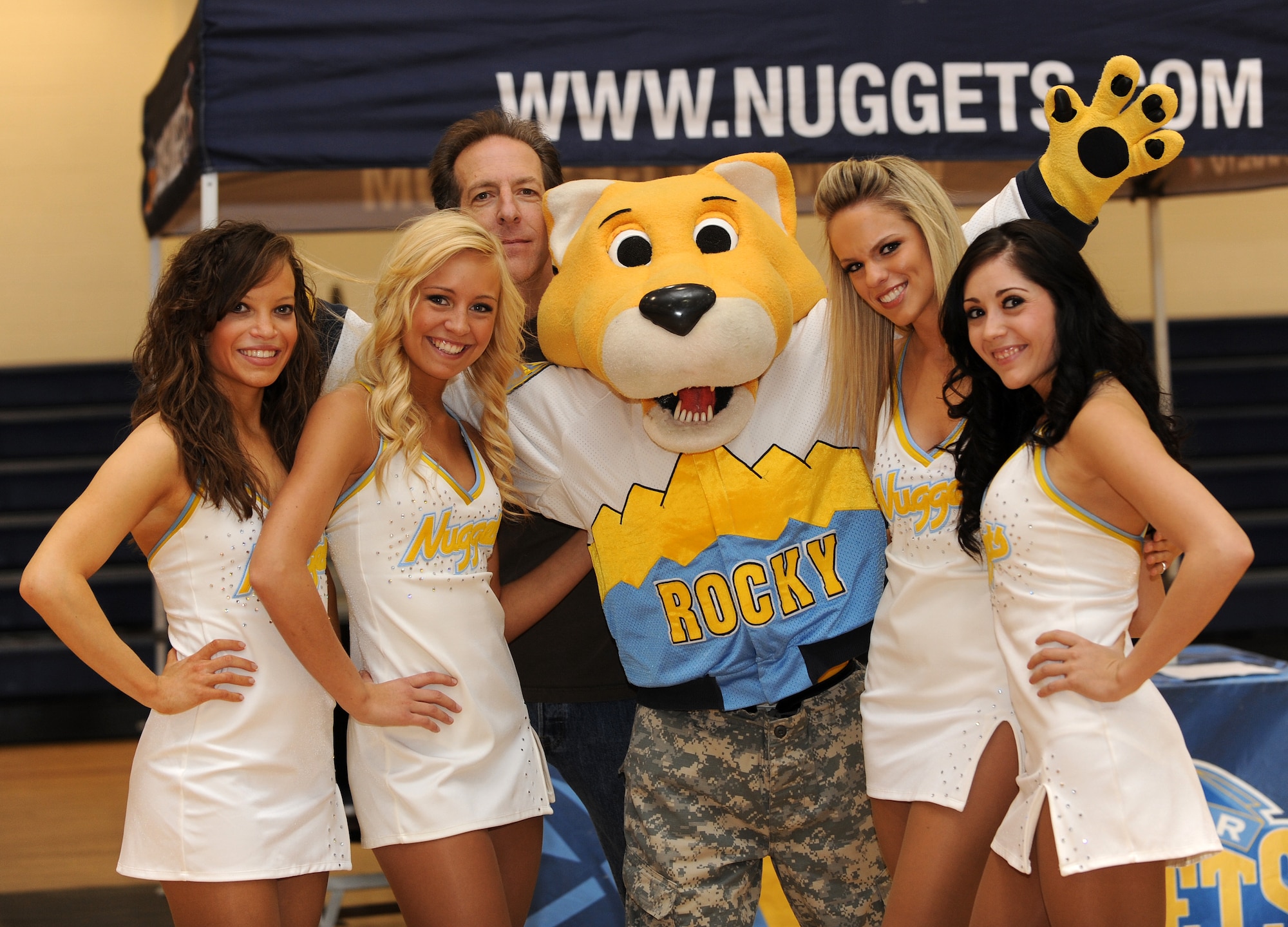 Buckley Air Force Base, Colo.-  Denver Nuggets mascot, Rocky and the dance team along with 98.5 KYGO DJ, Paul Donovan pose for a group photo on February 17, 2011. The local radio station, 98.5 KYGO and the Denver Nuggets teamed up to show their military appreciation.  ( U.S. Air Force Photo by Airman 1st Class Marcy Glass )
