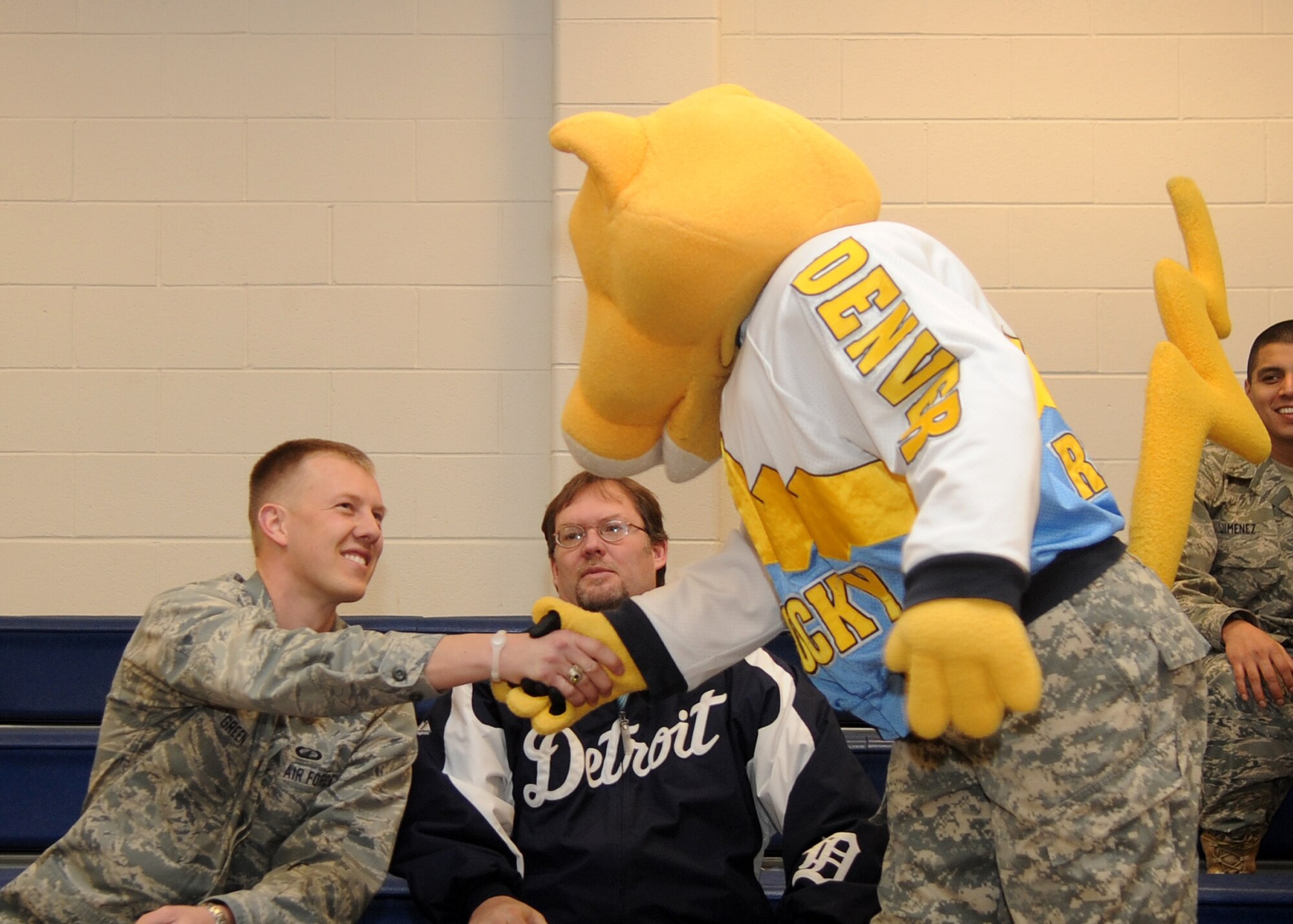 Buckley Air Force Base, Colo.-  1st Lt. Kenny Green, 460th Comptroller Squadron, shakes hands with the Denver Nuggets mascot, Rocky February 17, 2011. The local radio station, 98.5 KYGO came to Buckley AFB to celebrate military appreciation day. ( U.S. Air Force Photo by Airman 1st Class Marcy Glass )
