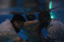 U.S. Air Force Senior Airmen Andrew Tilley and Abeoul Toure, candidates cross train into Combat Control exercise their buddy breathing skills during the Water Confidence Training at Hurlburt Field, Fla., Feb. 8, 2011. The training is designed to train candidates for the realities in combat. (U.S. Air Force photo by Airman 1st Class Caitlin O?Neil-McKeown/RELEASED)