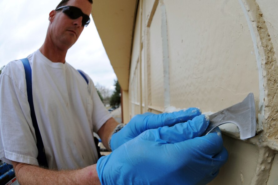 Stephen Jones, a contractor with a local painting company, shaves window glaze from the exterior of Hangar 11 in preparation for painting at Barksdale Air Force Base, La., Feb. 17. Hangar 11 is home to the 2nd Aircraft Maintenance Squadron support center. (U.S. Air Force photo/Senior Airman Brittany Y. Bateman)(RELEASED)