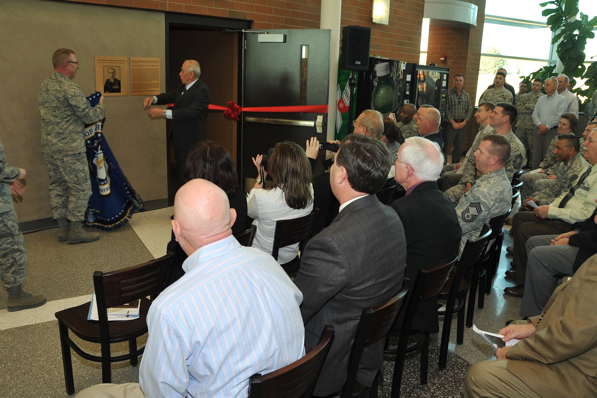 OFFUTT AIR FORCE BASE, Neb. -- Col. Robert Russell, Air Force Weather Agency commander, and Retired Chief Master Sgt. Peter Morris, unveil a plaque dedicating the AFWA auditorium to Chief Morris during a ceremony here Feb. 15. Chief Morris served 30 years in the Air Force and is widely recognized as one of their finest enlisted leaders and weather warriors. (Air Force photo by Jeff W. Gates)
