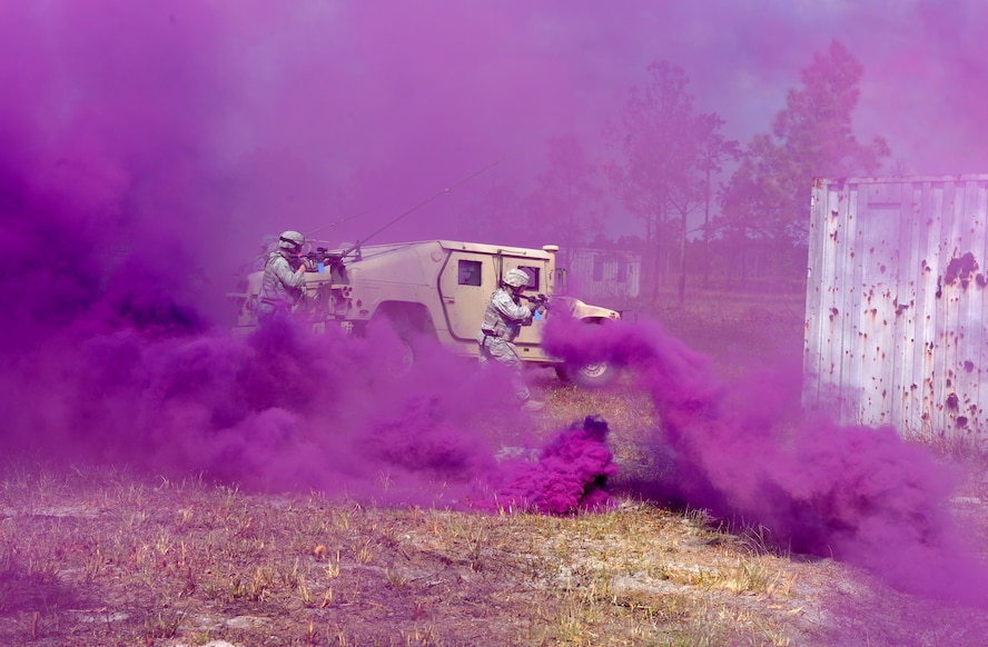 AVON PARK, Fla.-- Members of the 823rd Base Defense Squadron from Moody Air Force Base, Ga., travel behind a cloud of purple smoke during joint exercise ATLANTIC STRIKE 11-01 Feb. 16. The 823rd BDS invaded a mock village with support from a joint terminal attack controller calling in airstrikes during the exercise. (U.S. Air Force photo/Airman 1st Class Benjamin Wiseman)(RELEASED)