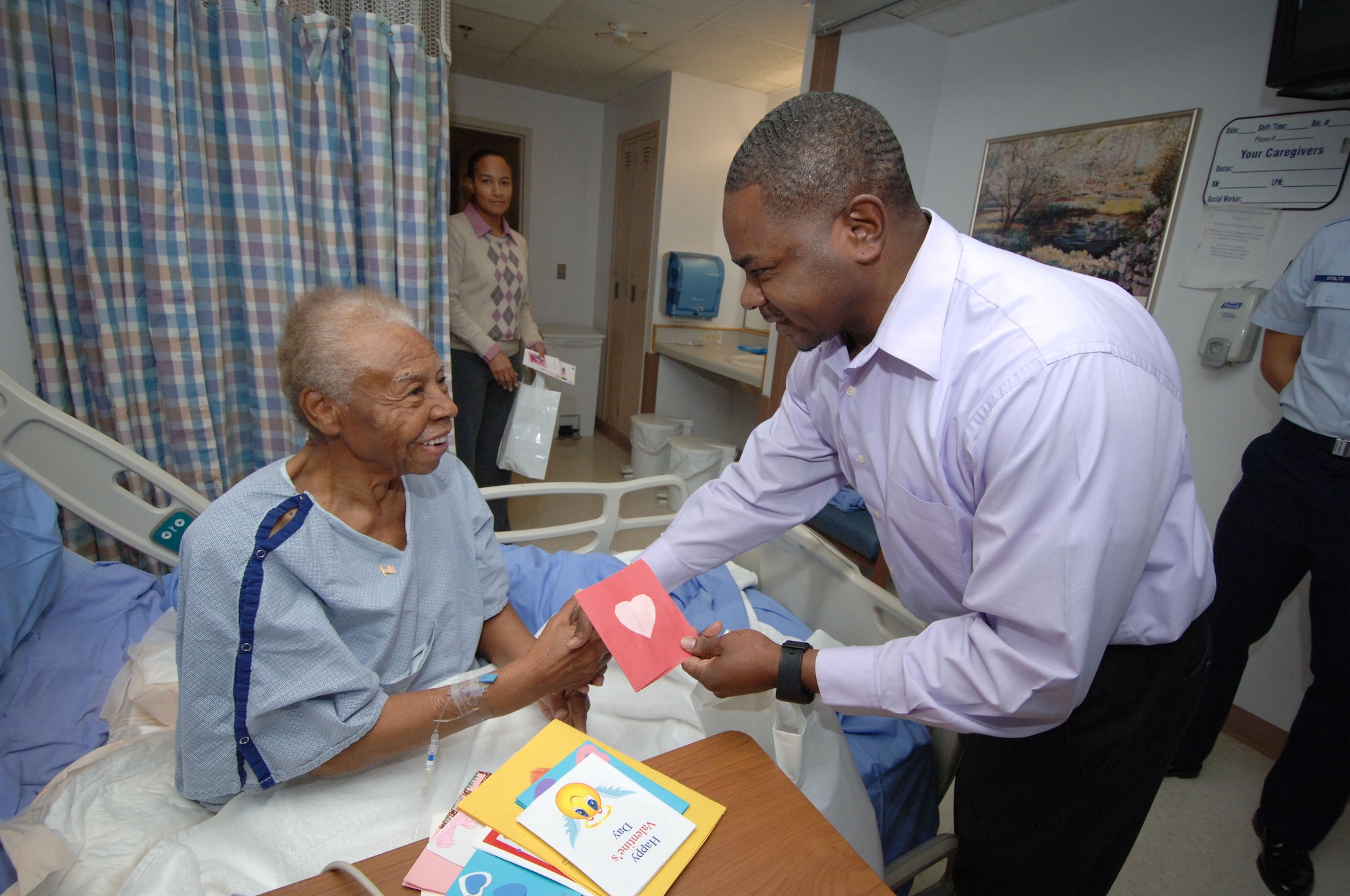 Glennie Wiggins smiles as Tyrone Golden of Air Force Program Executive Office Enterprise Information Systems delivers a card created by Maxwell Elementary School students at the Montgomery Regional Veterans Administration Hospital Monday. As part of the annual Valentines for Vets program, volunteers from Maxwell-Gunter delivered valentines and flags to veterans Monday at VA hospitals in Montgomery and Tuskegee.(Air Force photo/Melanie Rodgers Cox)