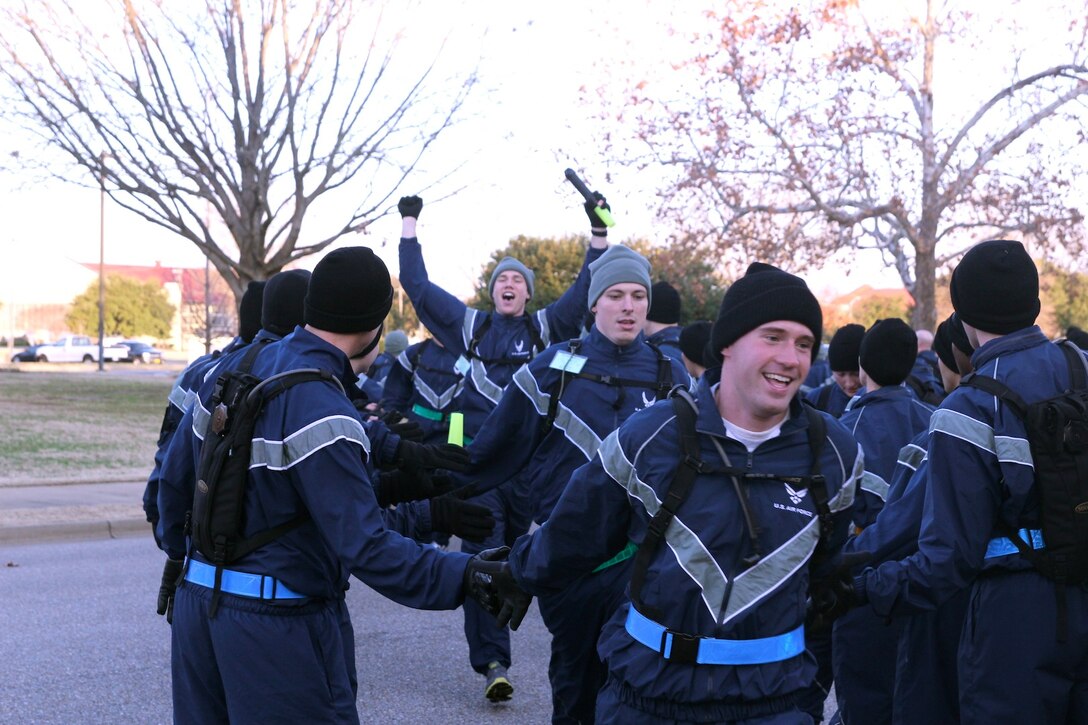 On Feb. 8, officer candidates from the Air National Guard and officer trainees from the active duty Air Force came together to mark a historical event for the Officer Training School's commissioning program. 

Shown here at the finish line are AMS Officer Candidate Shawn Corrigan from Flight 1-17, with Officer Trainees Isaac Dorau and Steven O'Farrell coming in behind him. 

The first joint Prop and Wings run was a shared common experience between the Academy of Military Science and the Basic Officer Training programs. 

"This morning's run was a remarkable way to reflect our Total Force," said Col. Roger Watkins, the Holm Center commander. "When we go to war, we go to war together. We have the same training requirements, the same deployment requirements and the same mission requirements, so it's only appropriate we take these kind of opportunities to work together as a Total Force team." 

About 230 students along with OTS staff and members from the 22nd Training Squadron ran more than five miles around historical Maxwell Air Force Base and paused to reflect on its great heritage. 

Colonel Watkins stressed the importance of the day's event to the students: "Today marks a distinct point in your training as future leaders. Be proud of what you've accomplished today, but don't rest on your laurels - your journey has just begun."

Air Force Photo/ Officer Trainee Joe Melendez)