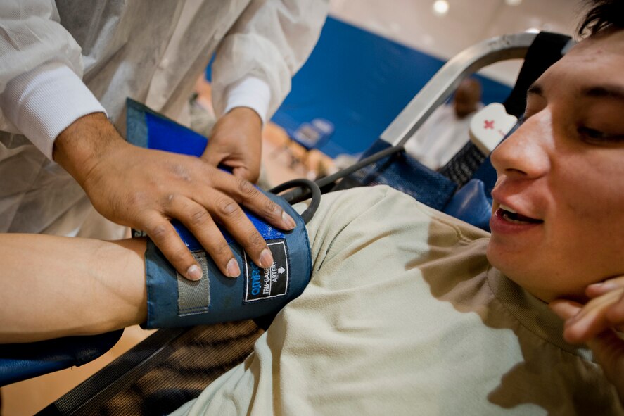 MOODY AIR FORCE BASE, Ga. -- Senior Airman Gerald Neal, 822nd Base Defense Squadron fire team member, watches as a sphygmomanometer cuff is applied to his arm Feb. 17 during a blood drive at the Freedom I Fitness Center. Once donated blood is properly tested and stored, it becomes available for shipment to hospitals 24 hours a day, 7 days a week. (U.S. Air Force photo/Staff Sgt. Jamal D. Sutter)(RELEASED)
