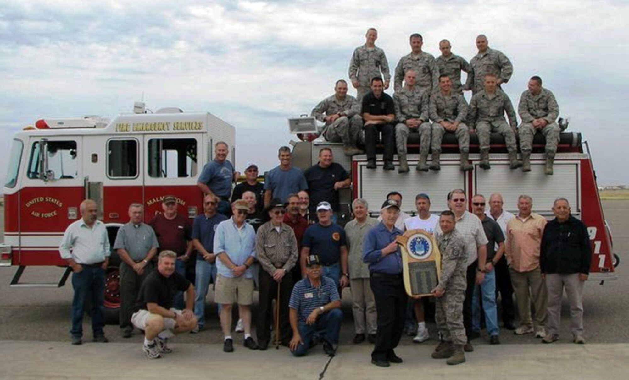Members of Malmstrom’s Fire Department (on top of fire truck) pose for a photo with the previous team from 1980.  Part of the two-day reunion was a tour of Malmstrom’s current fire station.  (Courtesy photo)