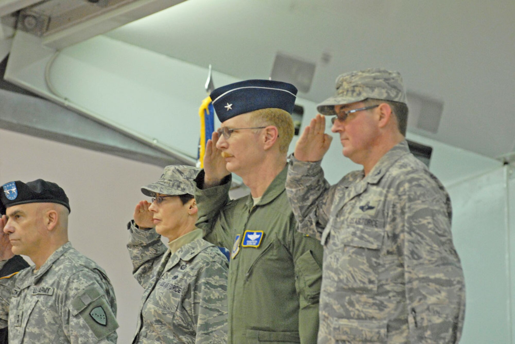 Air National Guard Brig. Gen. Charles Foster, 176th Wing commander, and Air Force Col. Robert Evans, JBER/673d Air Base Wing commander, salute the U.S. flag during
the 176th Wing arrival and JBER’s welcome at Hangar 18, Saturday. (U.S. Air Force photo/Steve White)